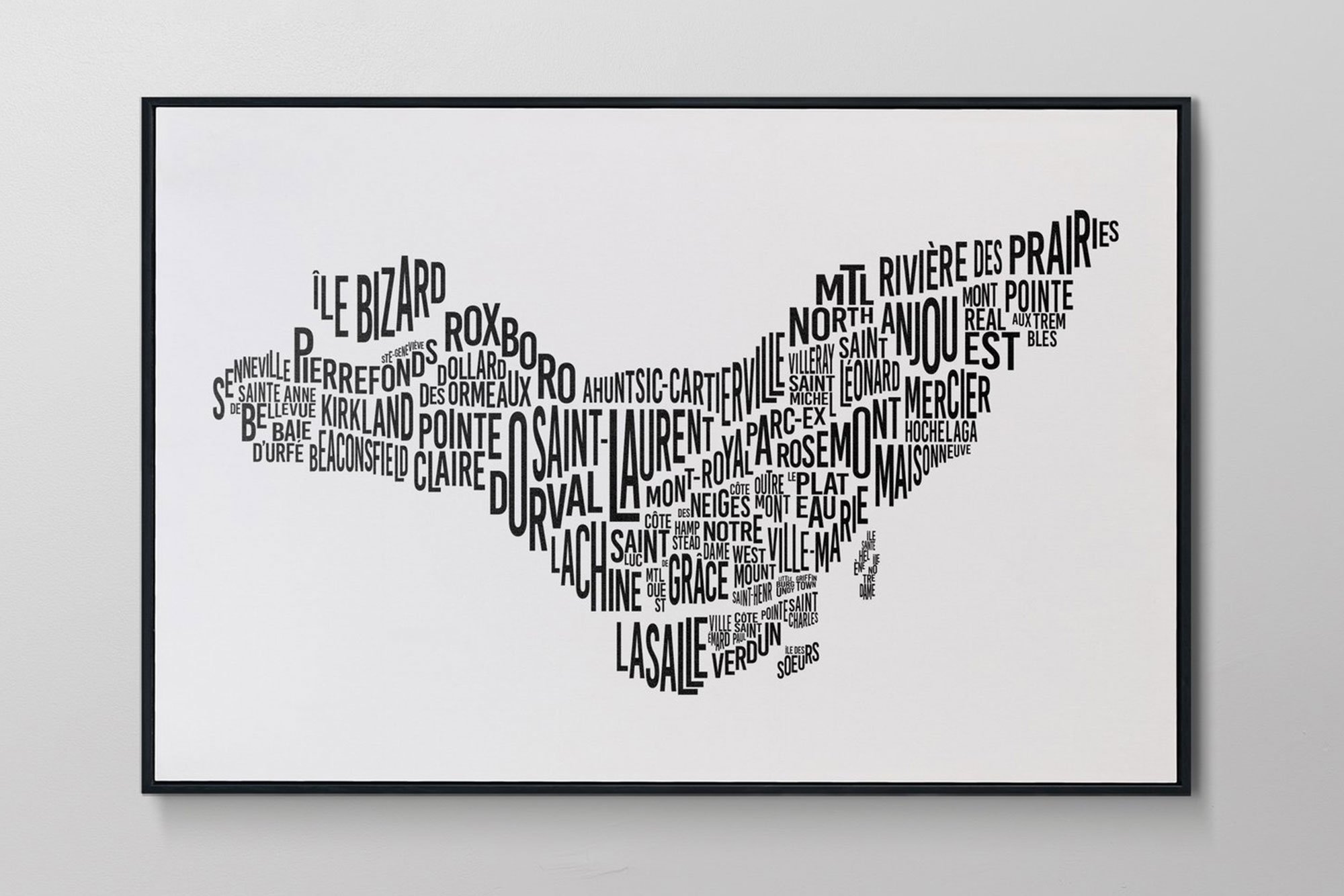 A framed artwork in the shape of a heart composed of the names of neighborhoods in Montreal.