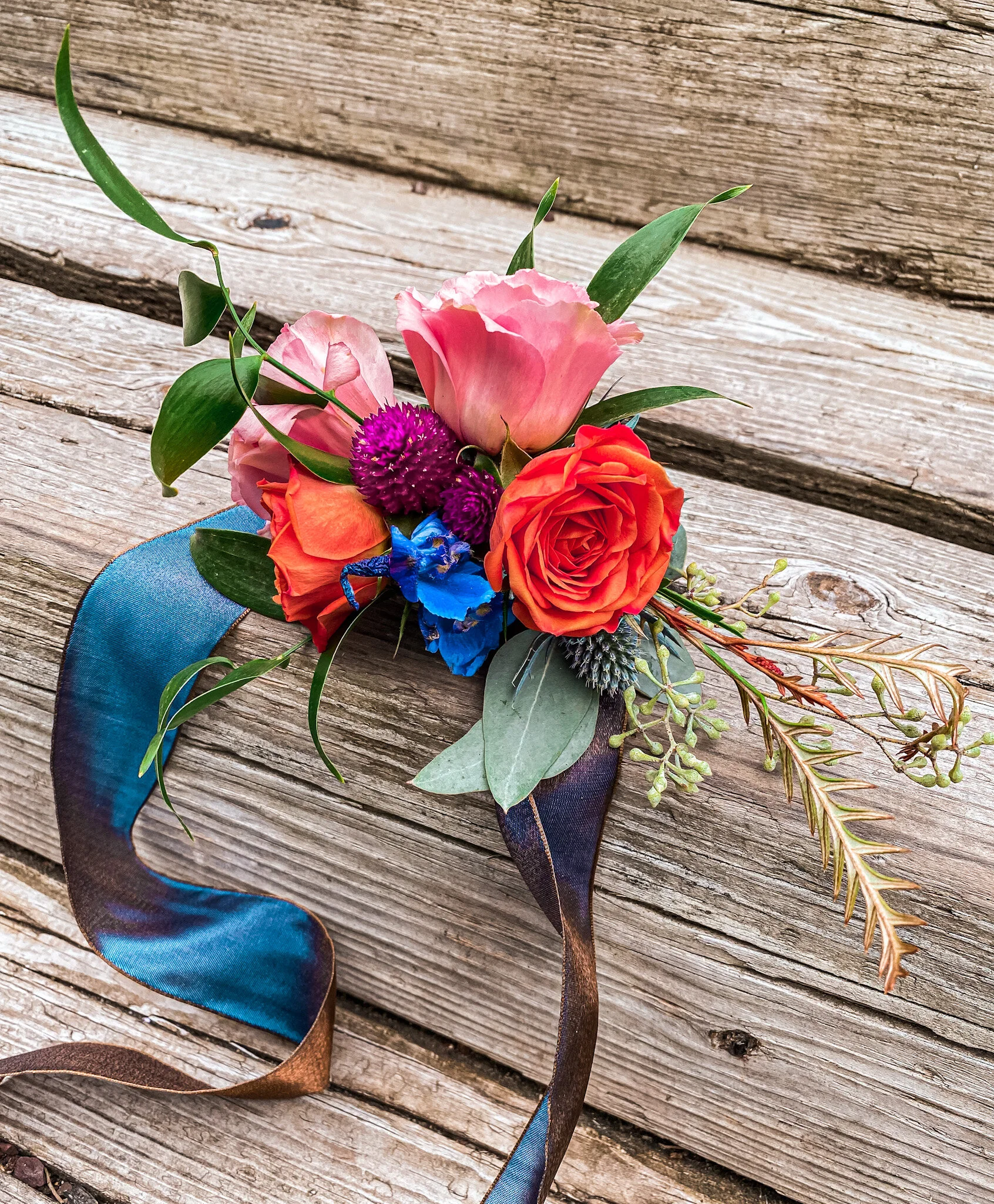 Gorgeous corsage with burnt orange and hints of blue.