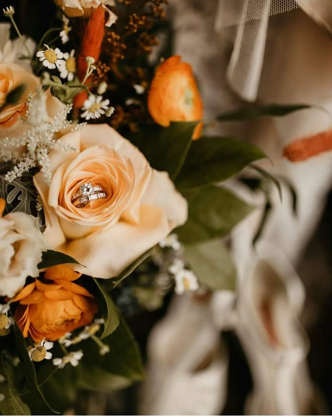Beautiful bridal bouquet with orange ranunculus with peach roses and astilbe.