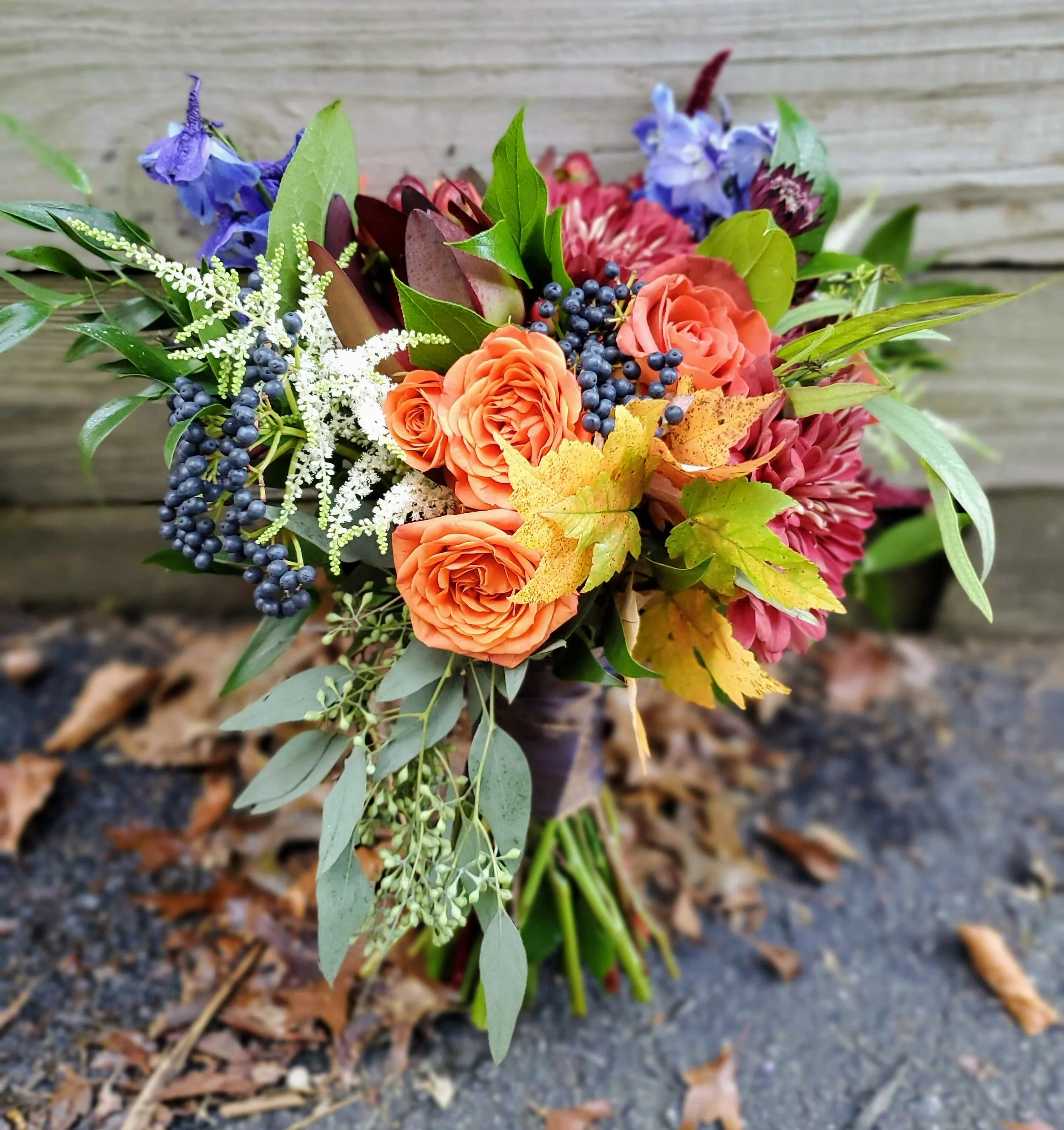 Vibrant fall wedding at Waterman Grill using privet berry, burnt orange spray roses, and deep red mums.