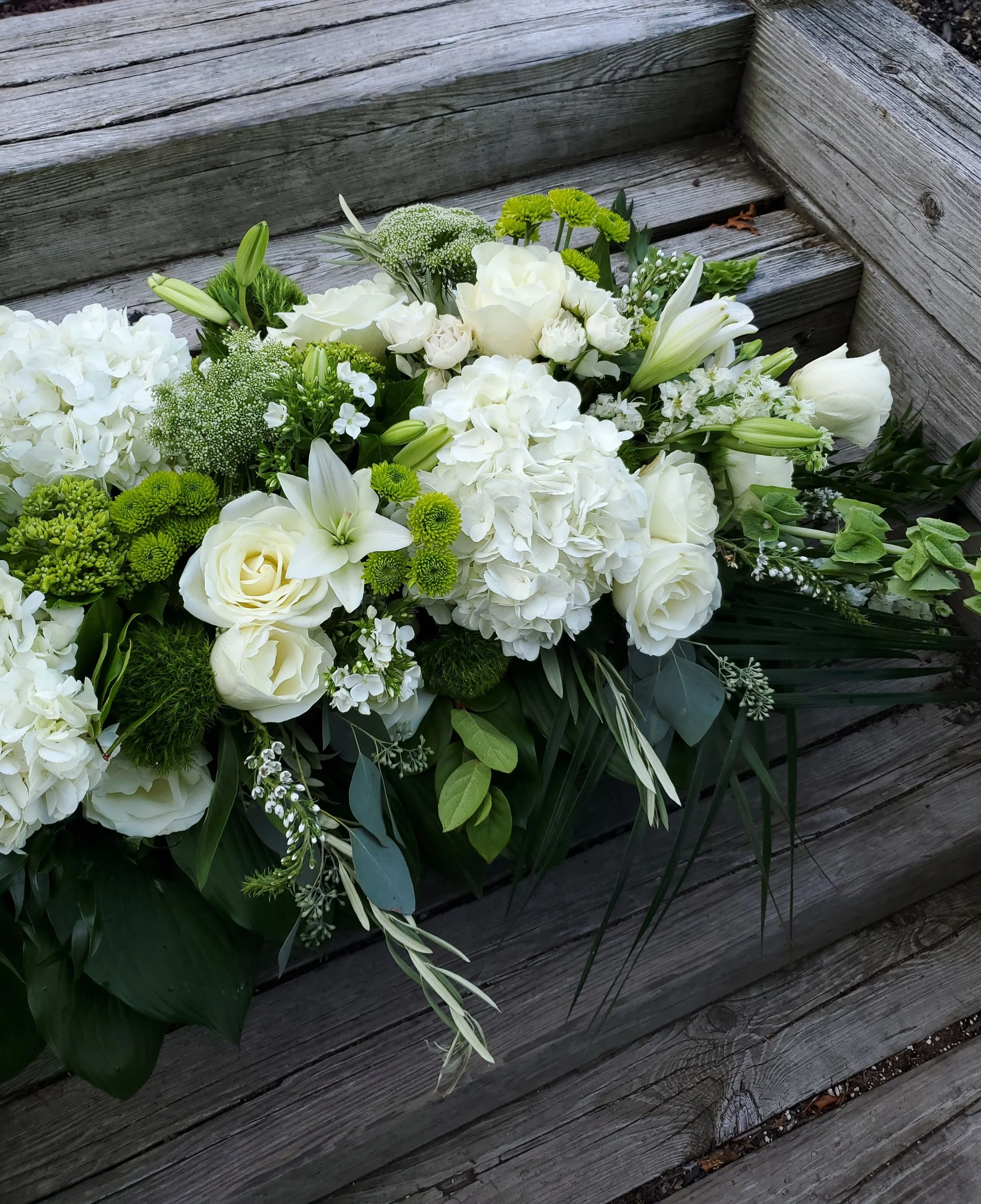 White hydrangea and roses with greens - Funeral Casket Spray - $300 to $575 - Half sprays start at $200