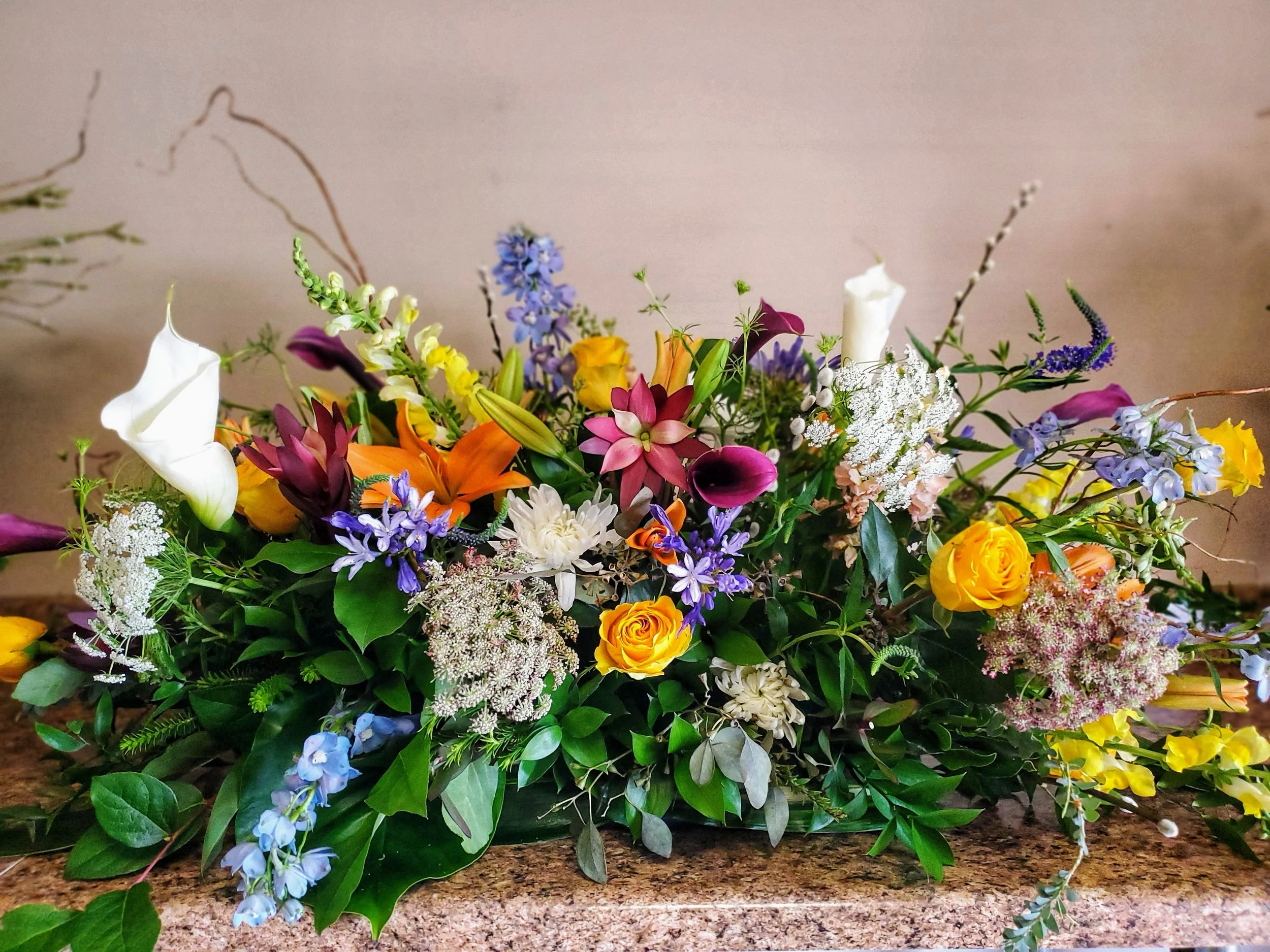 Earthy, wildflower funeral casket spray embracing one's inner nature and curious soul. - $300 to $575 - Half sprays start at $200