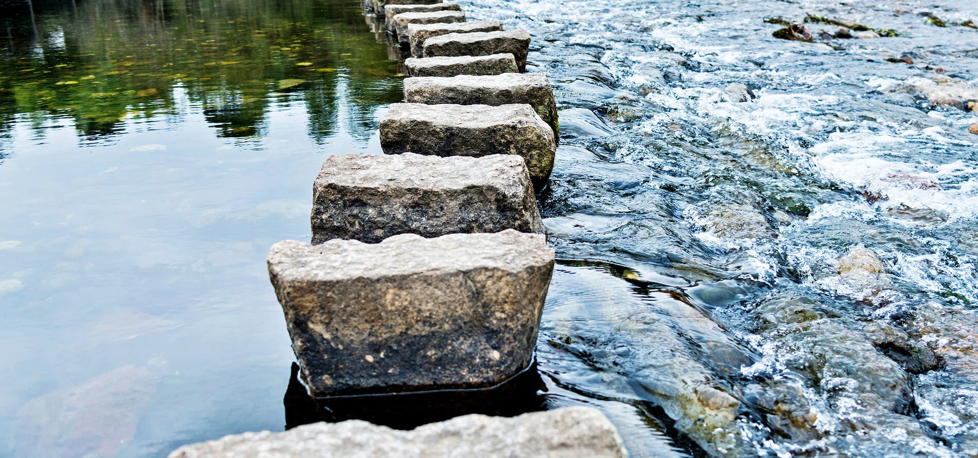 Rectangle rocks aligned straight along a coursing river.jpg