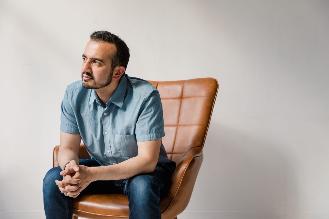 man-in-blue-button-up-shirt-sitting-on-brown-leather-armchair
