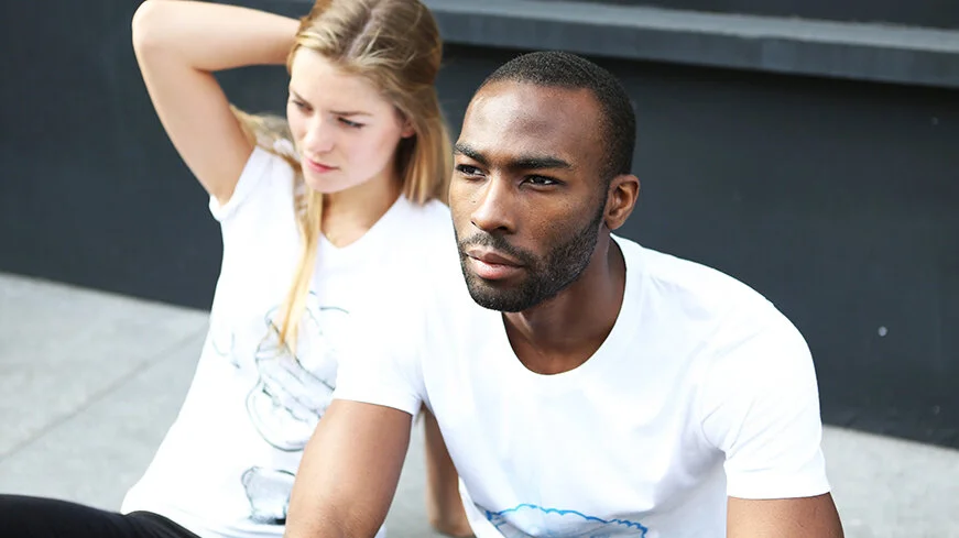 A woman and a man sitting outdoors, appearing to be in a contemplative mood.