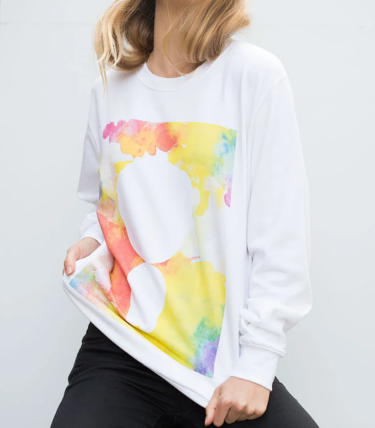A person wearing a white sweatshirt with a colorful watercolor-style printed map of the United States on the front, against a plain light background.