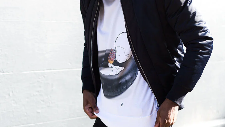 Person wearing a black jacket and a white t-shirt with a baby in a tire illustration.