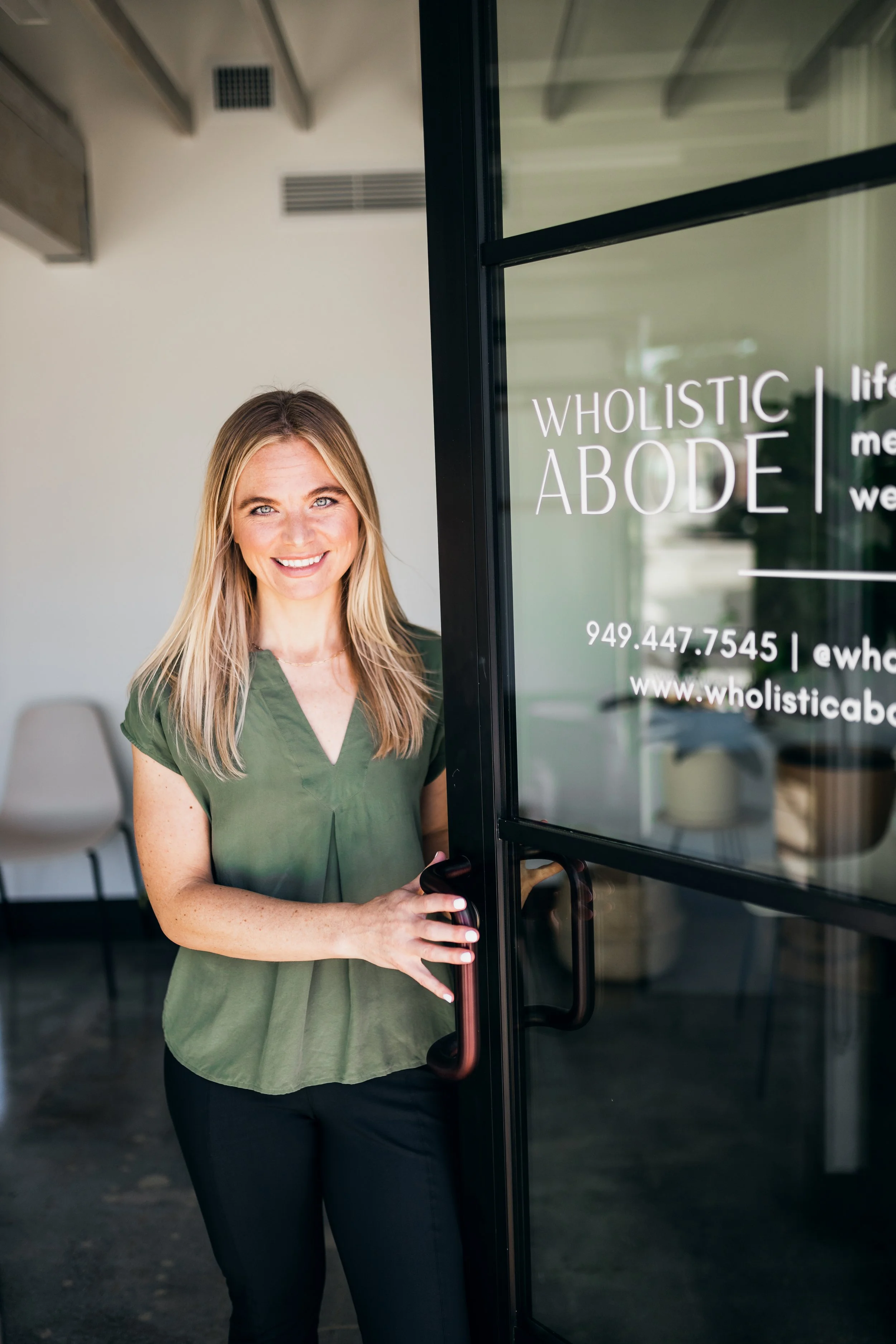 Dr. Julie Stefanski, female chiropractor, welcoming a patient into Wholistic Abode Chiropractic in Newport Beach