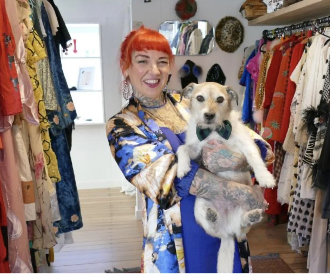 Claire from Vintage Liberation holding her dog in her vintage clothing shop in Queenstown