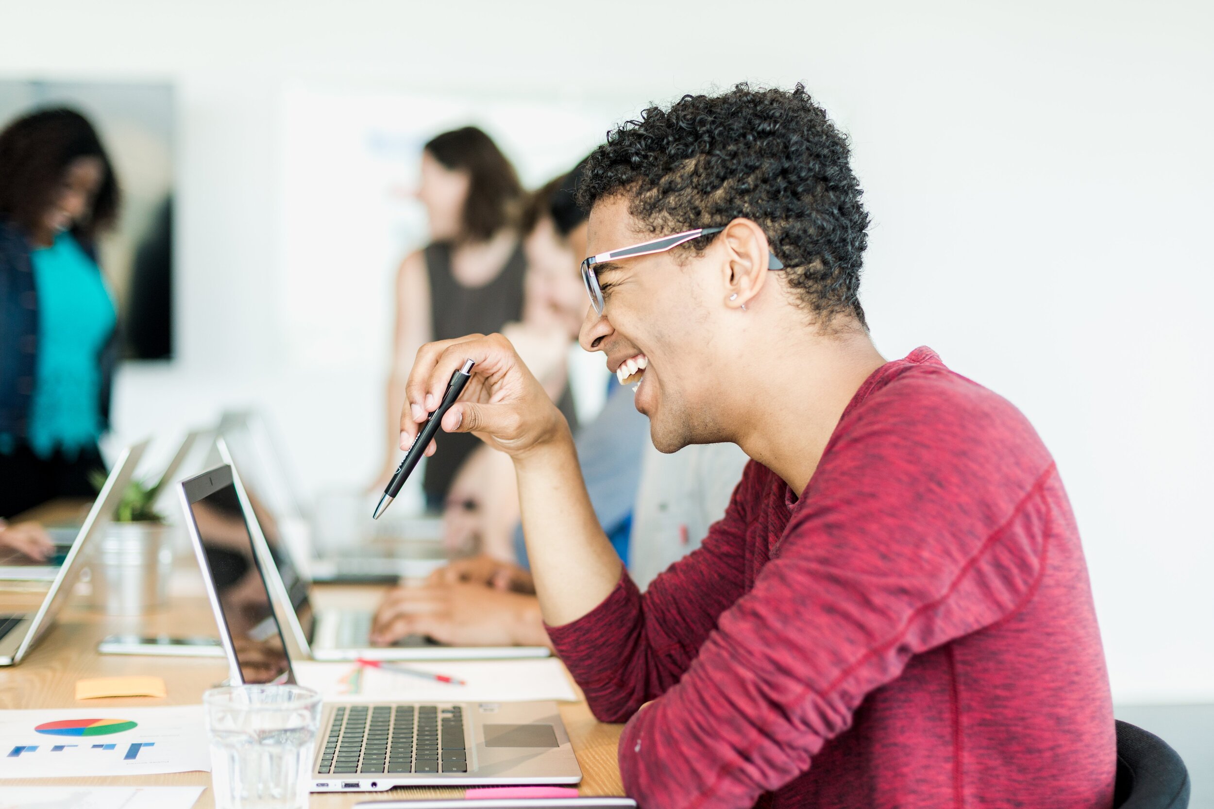 laughing-man-holding-pen-in-meeting.jpg