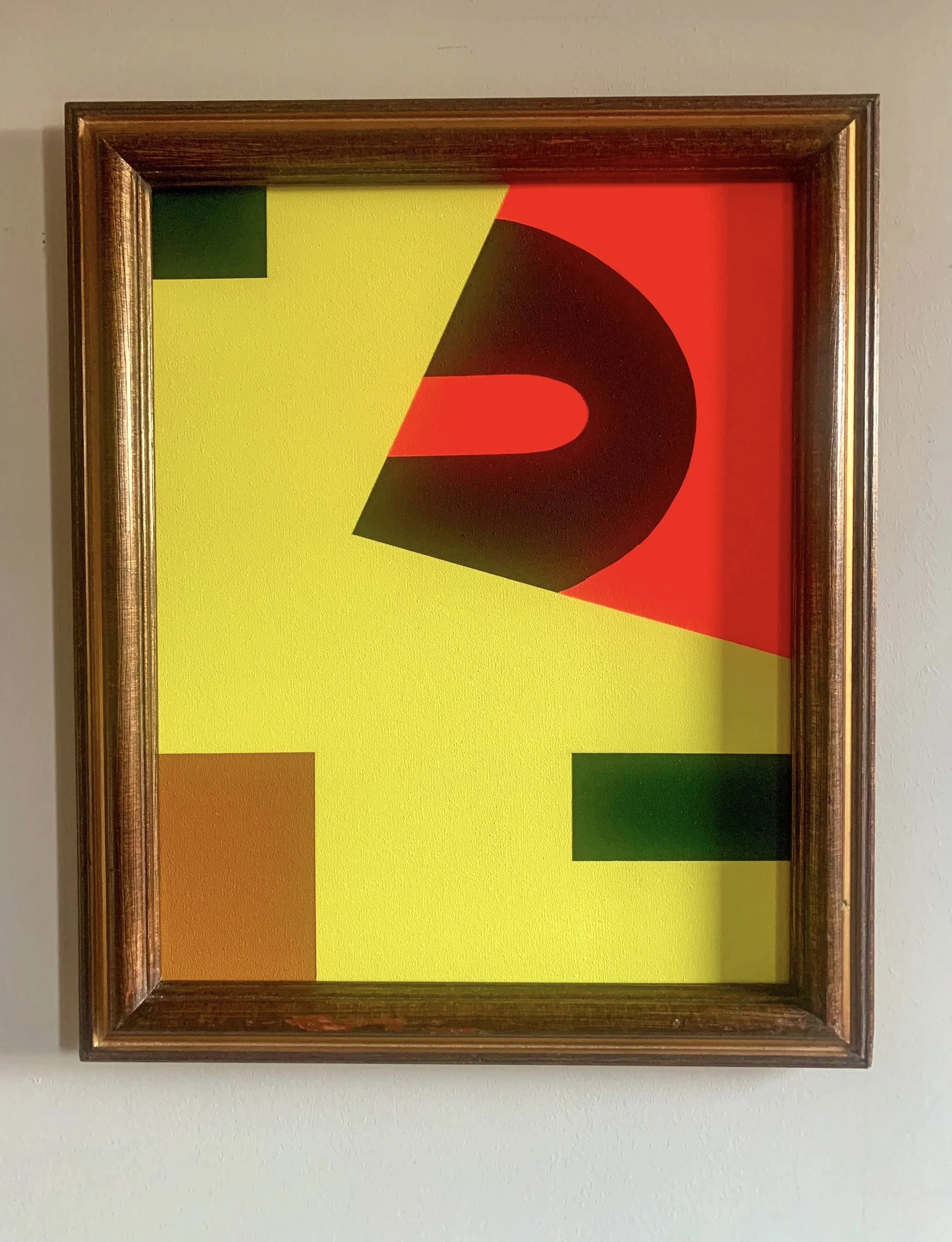 Minimalist color field artwork with red, orange, green, and ochre, framed and hung on a white wall, next to a white vase with a delicate dried branch.