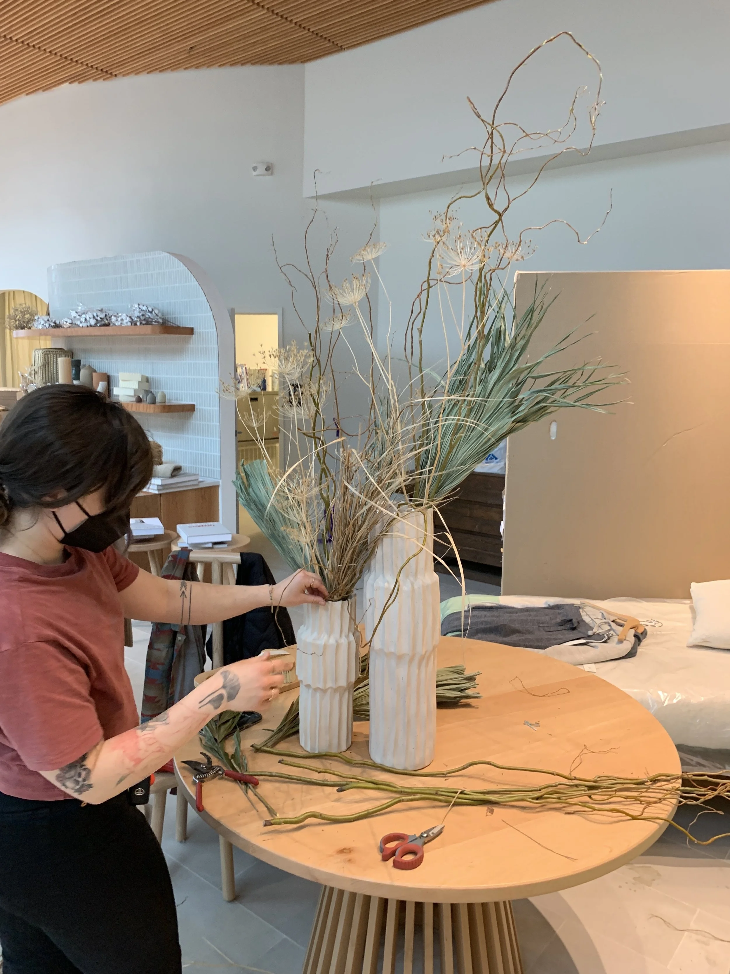 Angelene arranging dried flowers on-site for luxury brand store opening. 