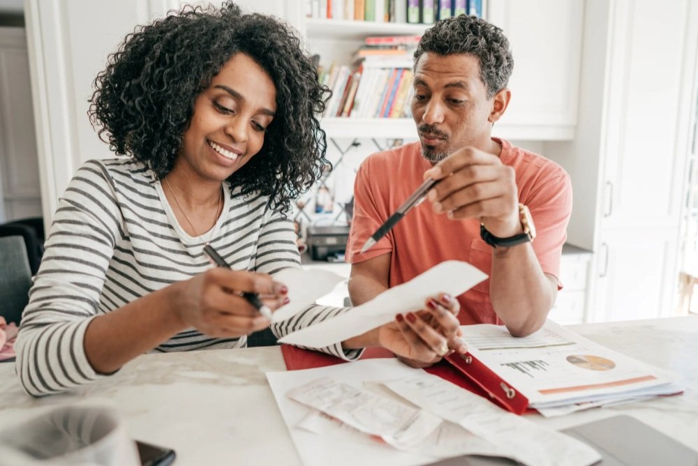 Couple sitting at table and working on taxes together