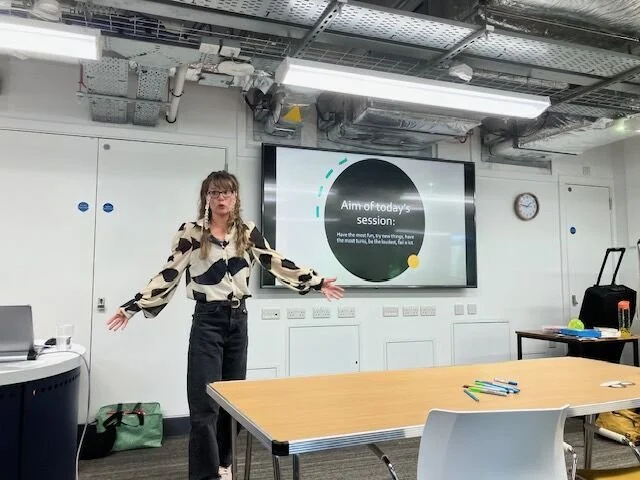 Lynn in front of a screen presenting