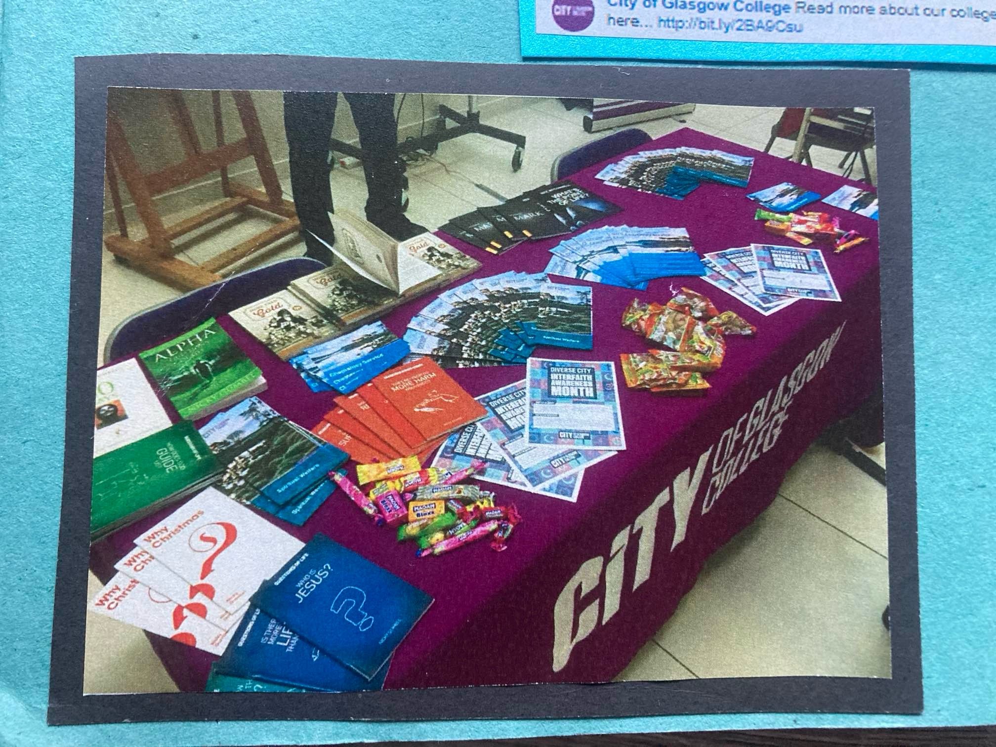 Image of table with leaflets, and the "City of Glasgow College" in a white font on a purple table cloth
