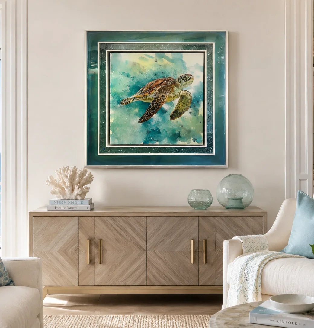 framed acrylic sea turtle painting displayed as coastal wall decor above a wooden sideboard in a bright living room.