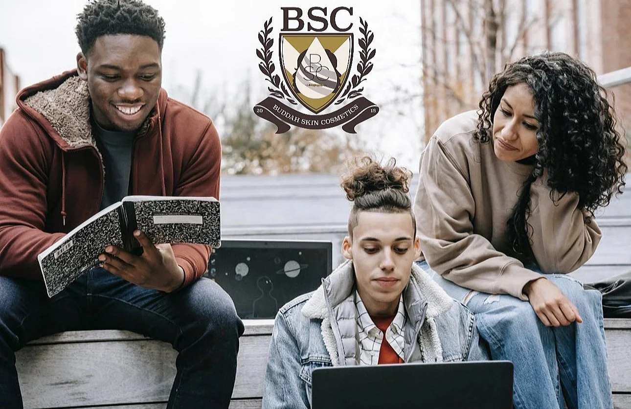 Three young adults sitting outdoors on a bench, two men and one woman, looking at laptops and notebooks, with a logo of Buddah Skin Cosmetics above them.