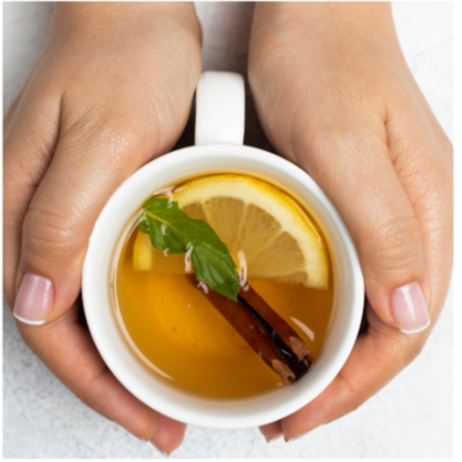 hands holding a cup of tea with lemon