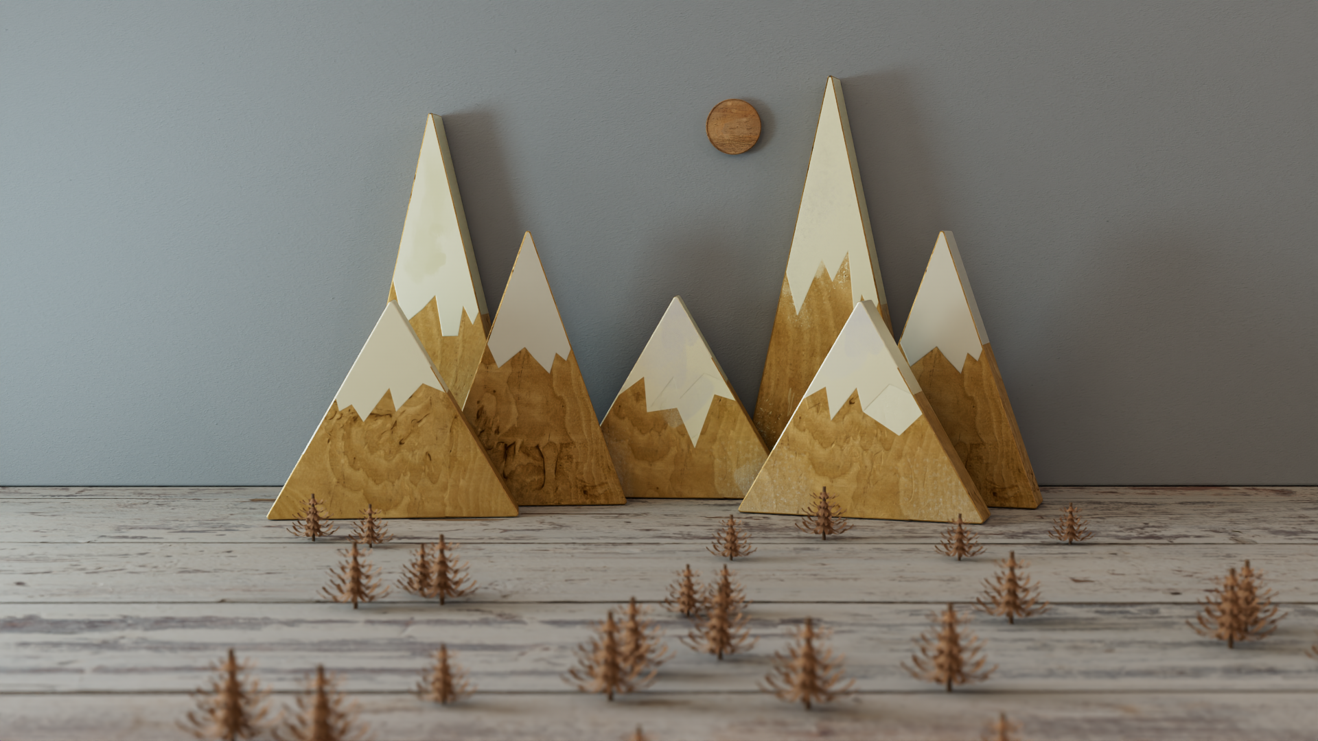 Decorative wooden mountain sculptures with white snow caps and small pine trees arranged on a rustic wooden surface against a gray wall.