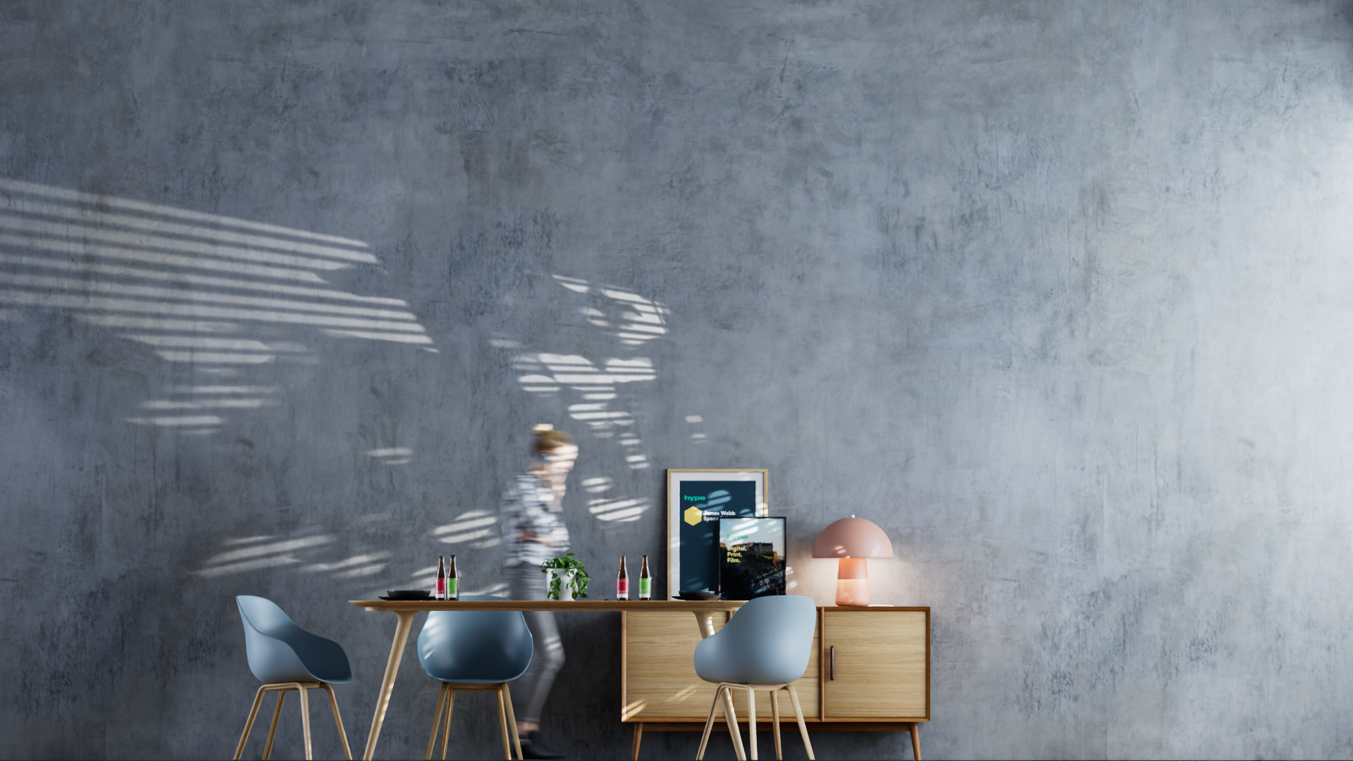Modern dining room with a wooden table, four light blue chairs, a sideboard with framed artwork, a pink lamp, and a person in motion in front of a textured gray wall with shadows from window blinds.