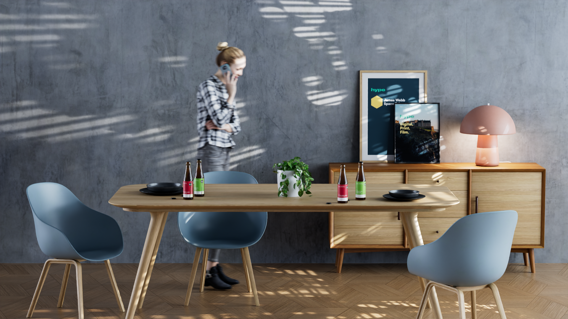 A woman in a checkered shirt talking on her phone in a modern dining room. There is a light wooden dining table with blue chairs, some beer bottles, a potted plant, and a sideboard with framed posters, a pink table lamp, and a cityscape picture. Sunl
