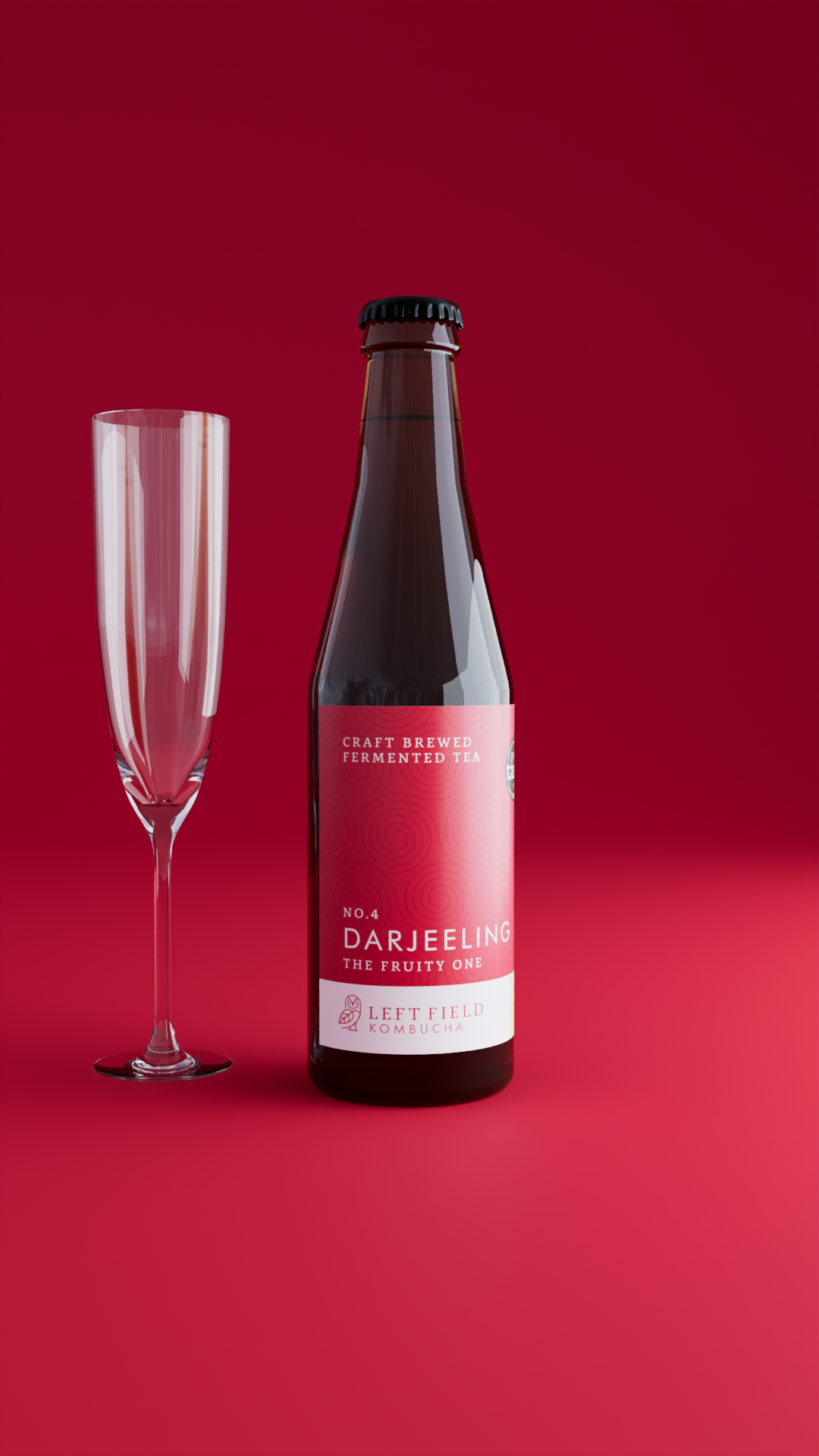 A bottle of craft brewed fermented tea with a pink label next to a champagne flute against a red background.