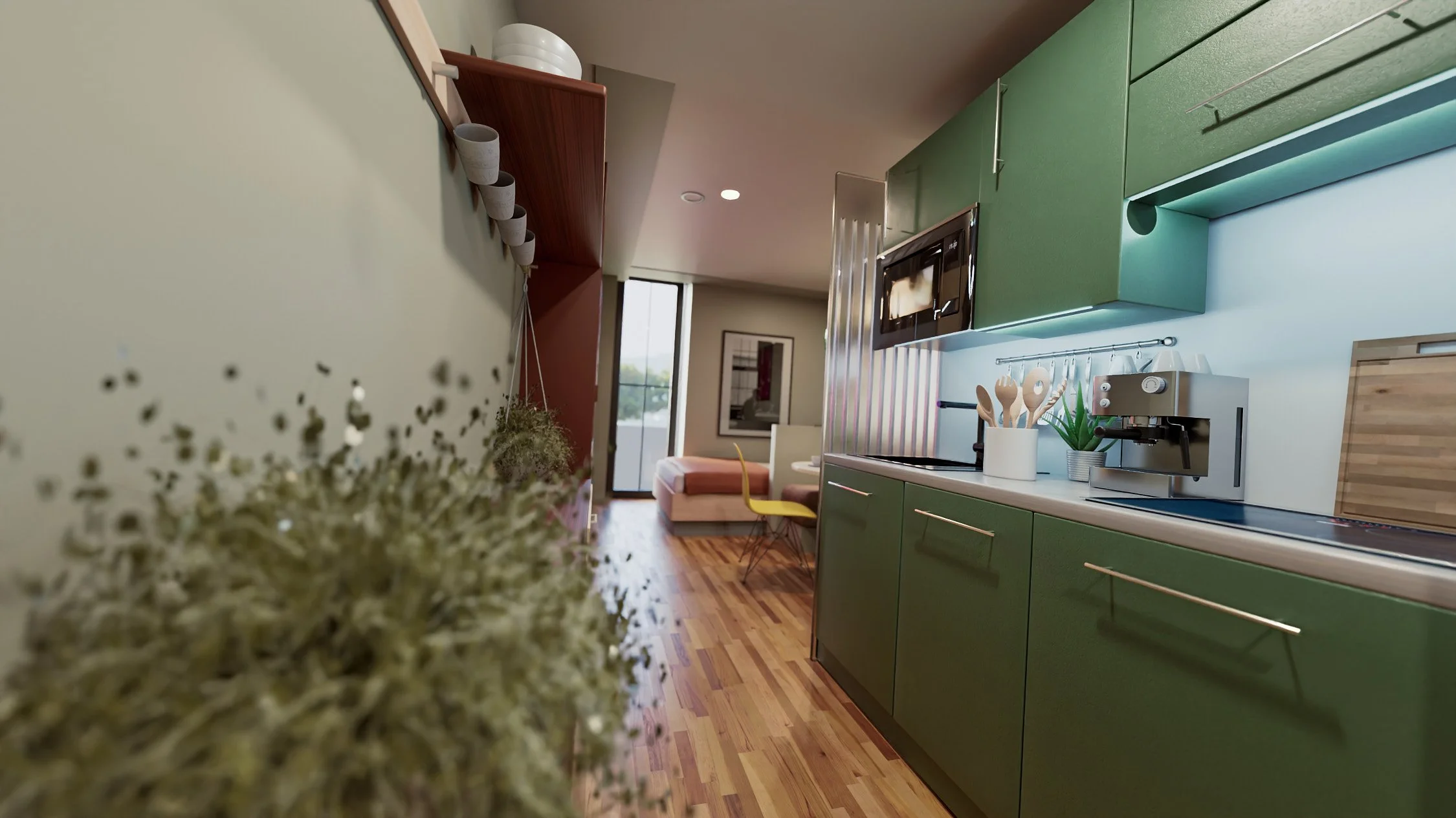 Interior view of a modern kitchen and living space with green cabinetry, wooden flooring, and a small dining area in the background.