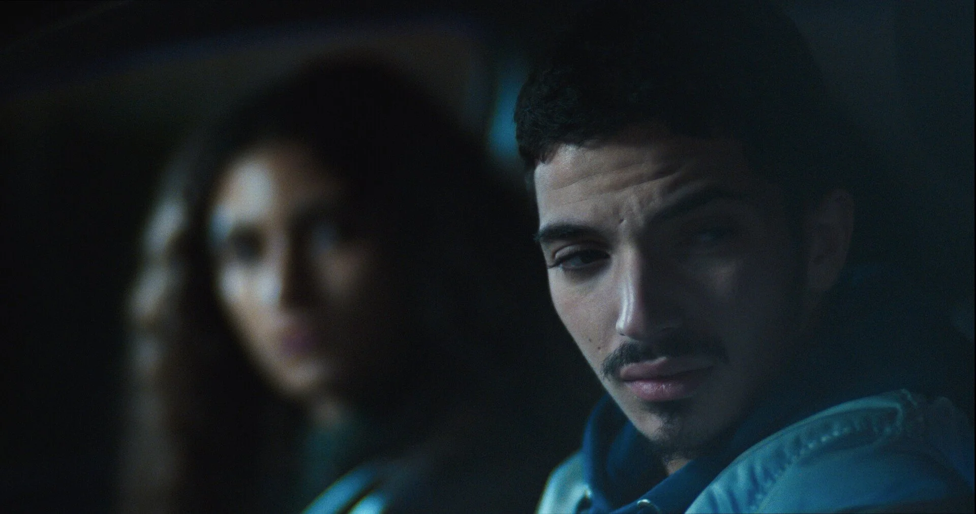 a man looking out the window with a woman looking at him