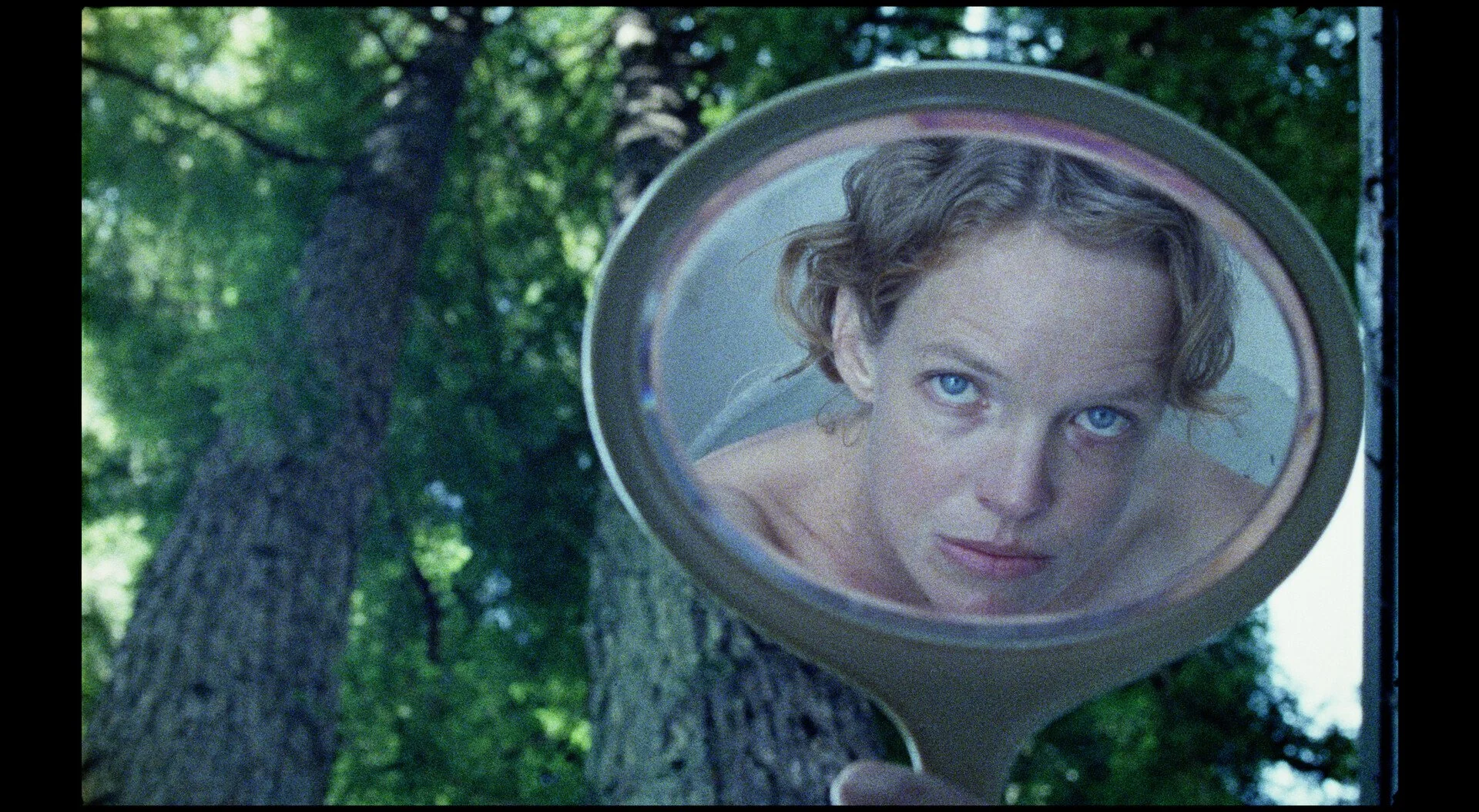 woman looking through mirror