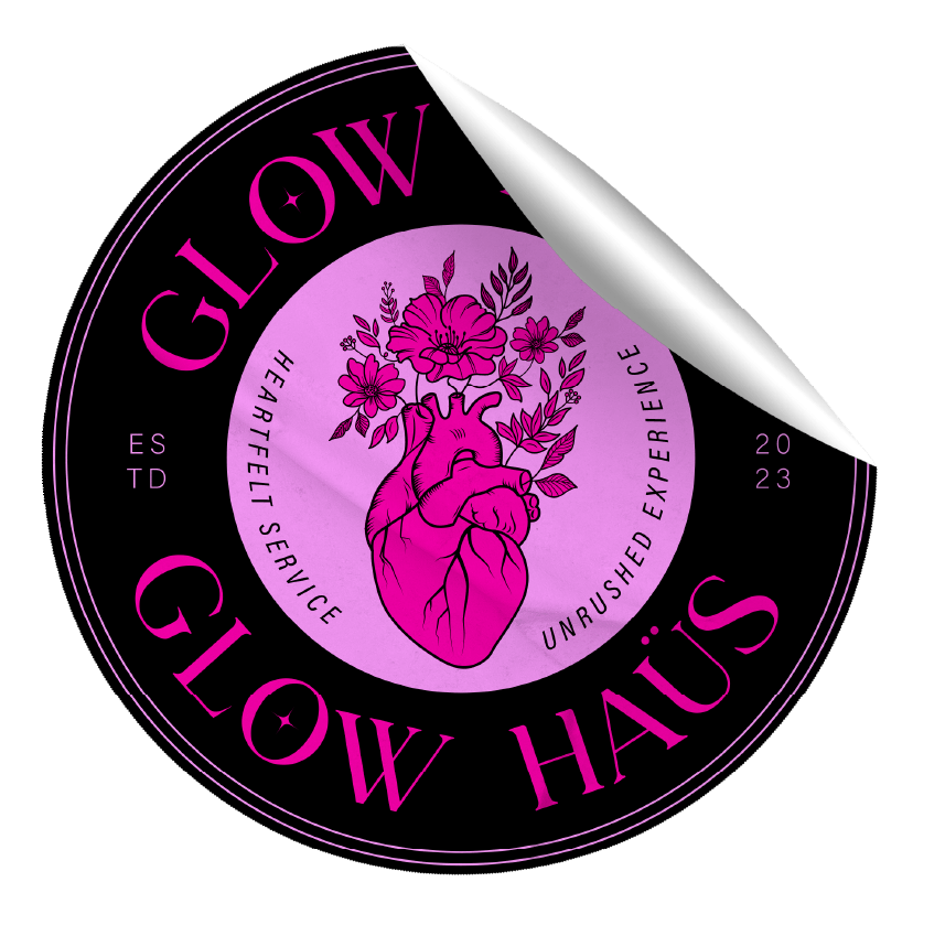 A circular sticker with a black background and pink accents. It features an illustration of a human heart with flowers growing out of it. The text reads 'GLOW Haus' and 'HEARTFELT SERVICE' and 'UNRUSHED EXPERIENCE,' with the year '2023' on the side.