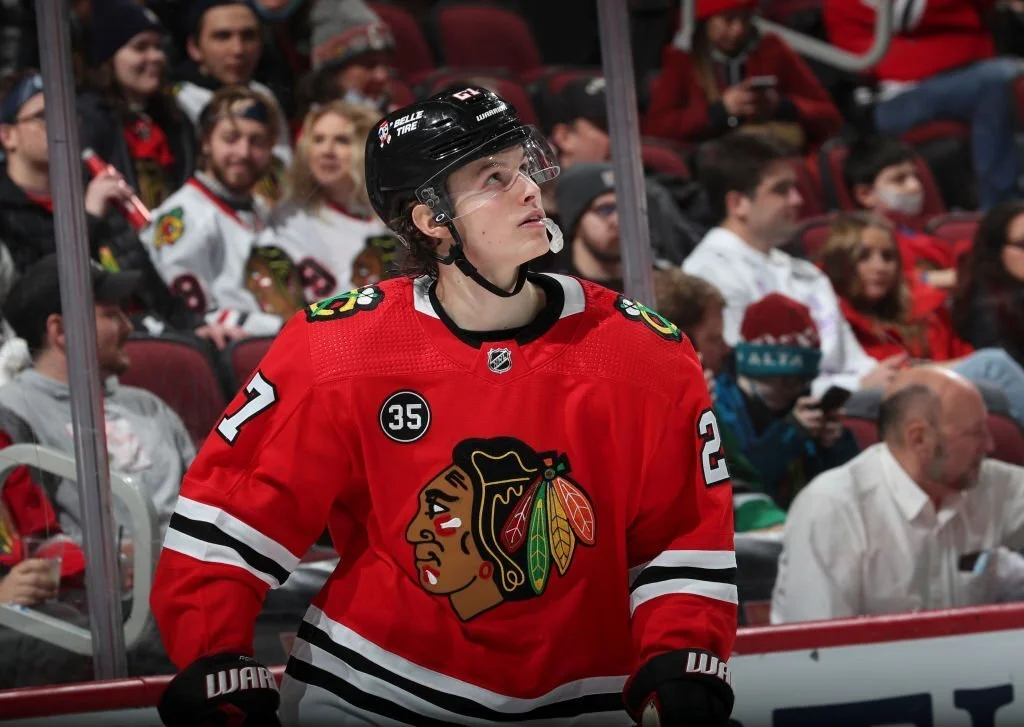 Lukas Reichel of the Chicago Blackhawks wearing the home red jerseys on the ice at the United Center