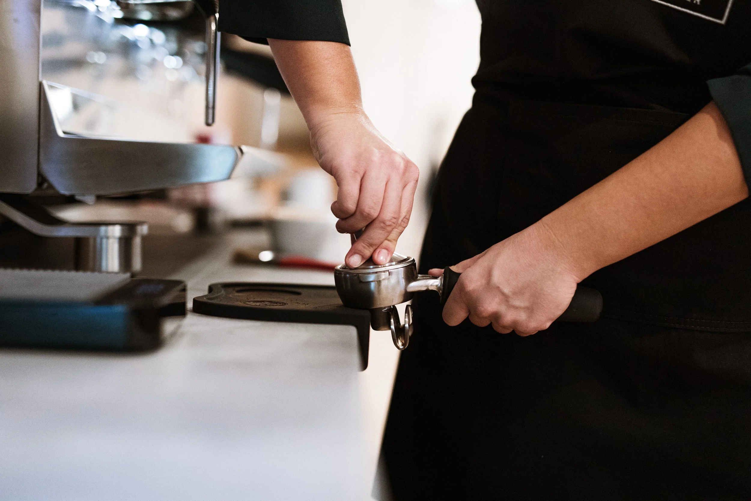 making espresso, tamping coffee