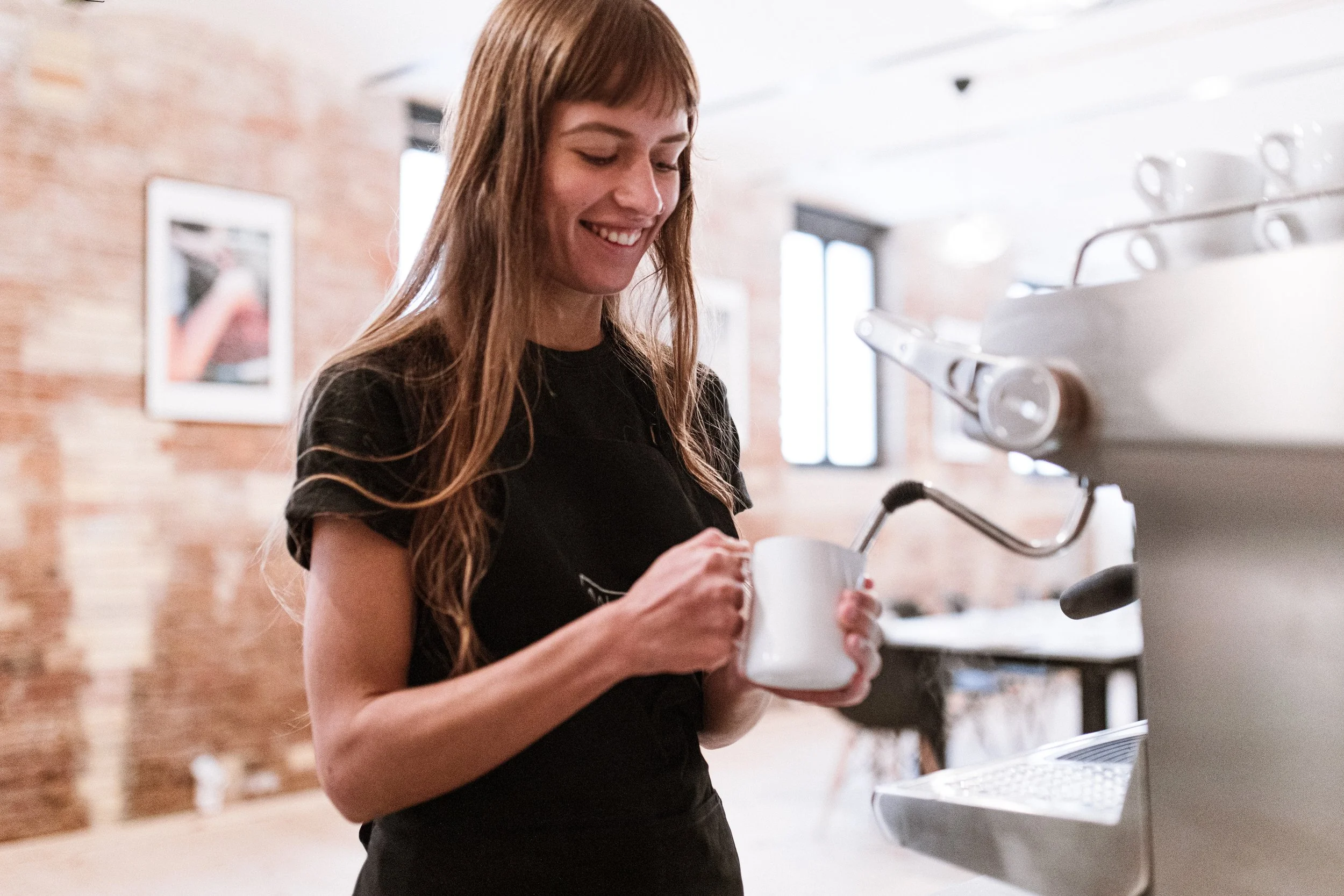 barista steaming milk for latte art