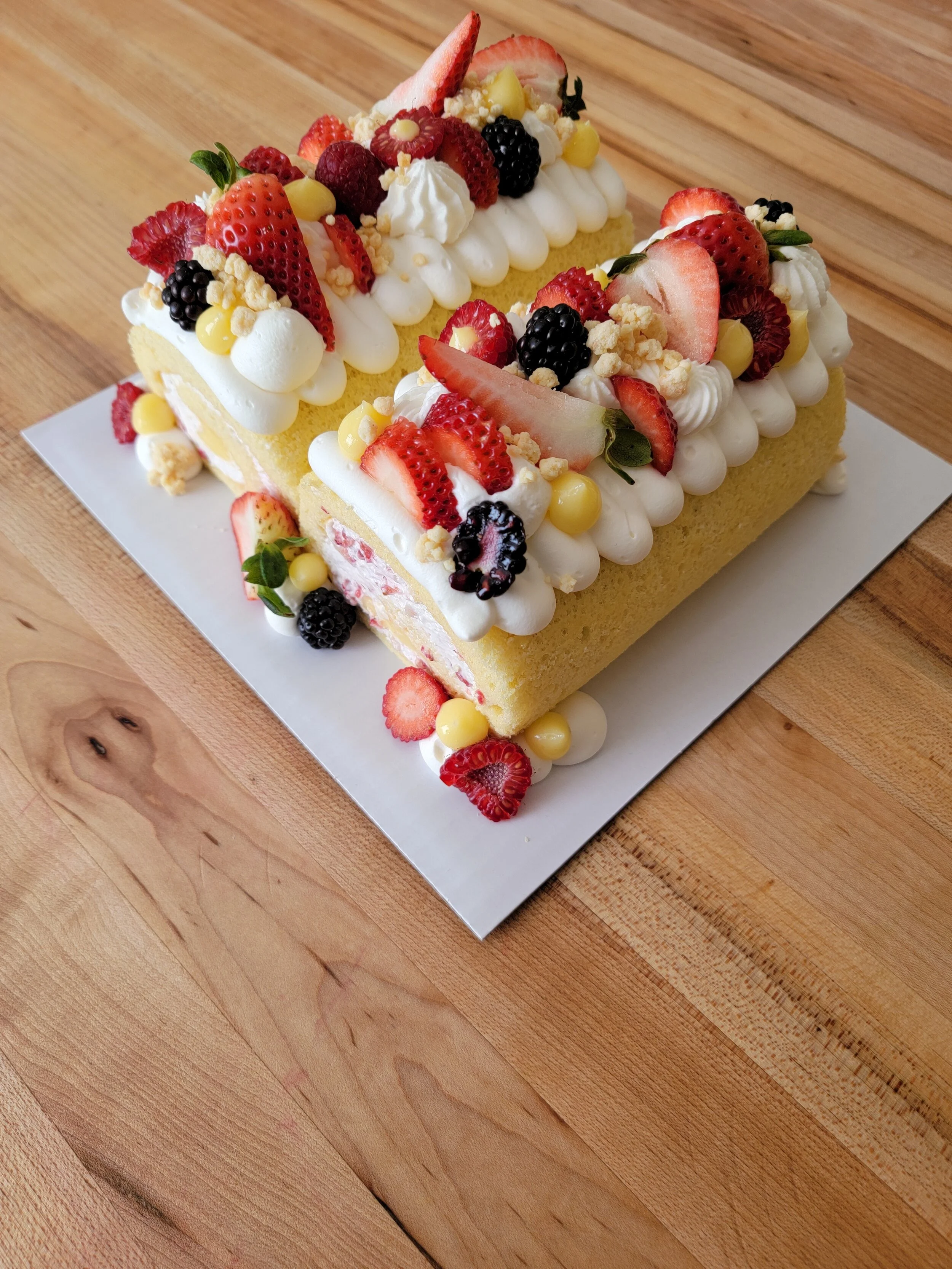 roll cake, strawberry cream, mix berries on top