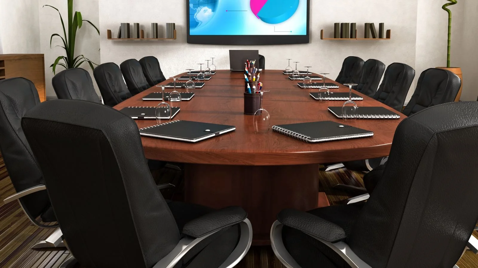 Conference room with a large wooden oval table surrounded by black leather chairs, notebooks, pens, upside-down glasses, a central container with pens, a large screen on the wall, shelves with books, and plants in the background.
