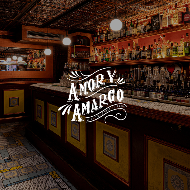 Interior of a bar with a wooden counter, shelves stocked with liquor bottles, and warm lighting from hanging globes.