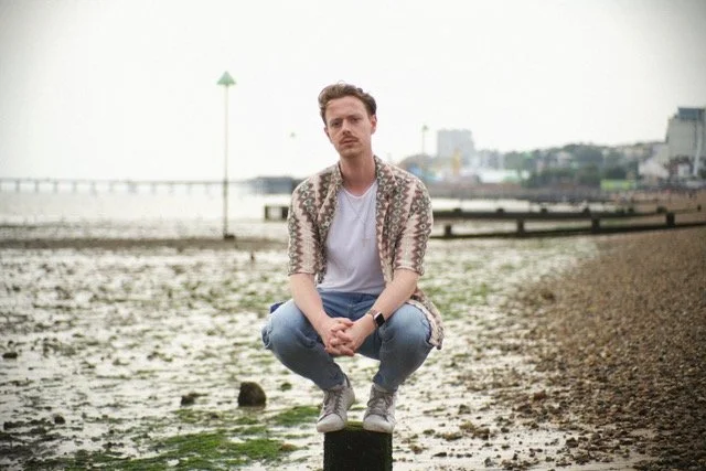 Person squatting on a rocky beach
