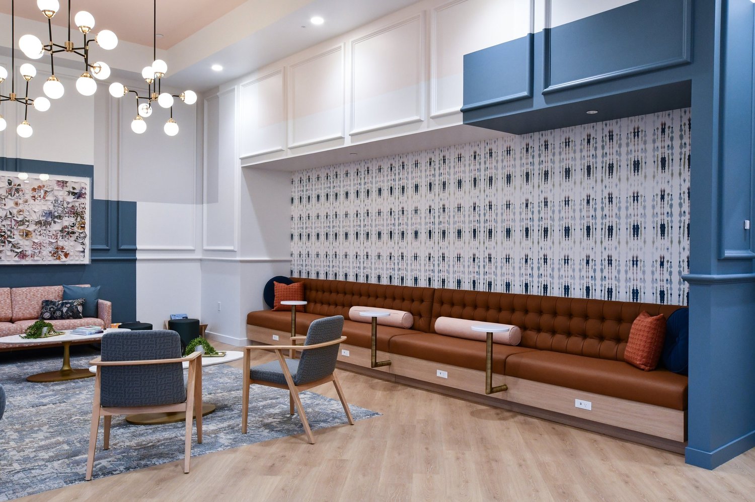 Waiting lounge: blue joinery, warm leather banquette and globe lighting; editorial architectural detail.