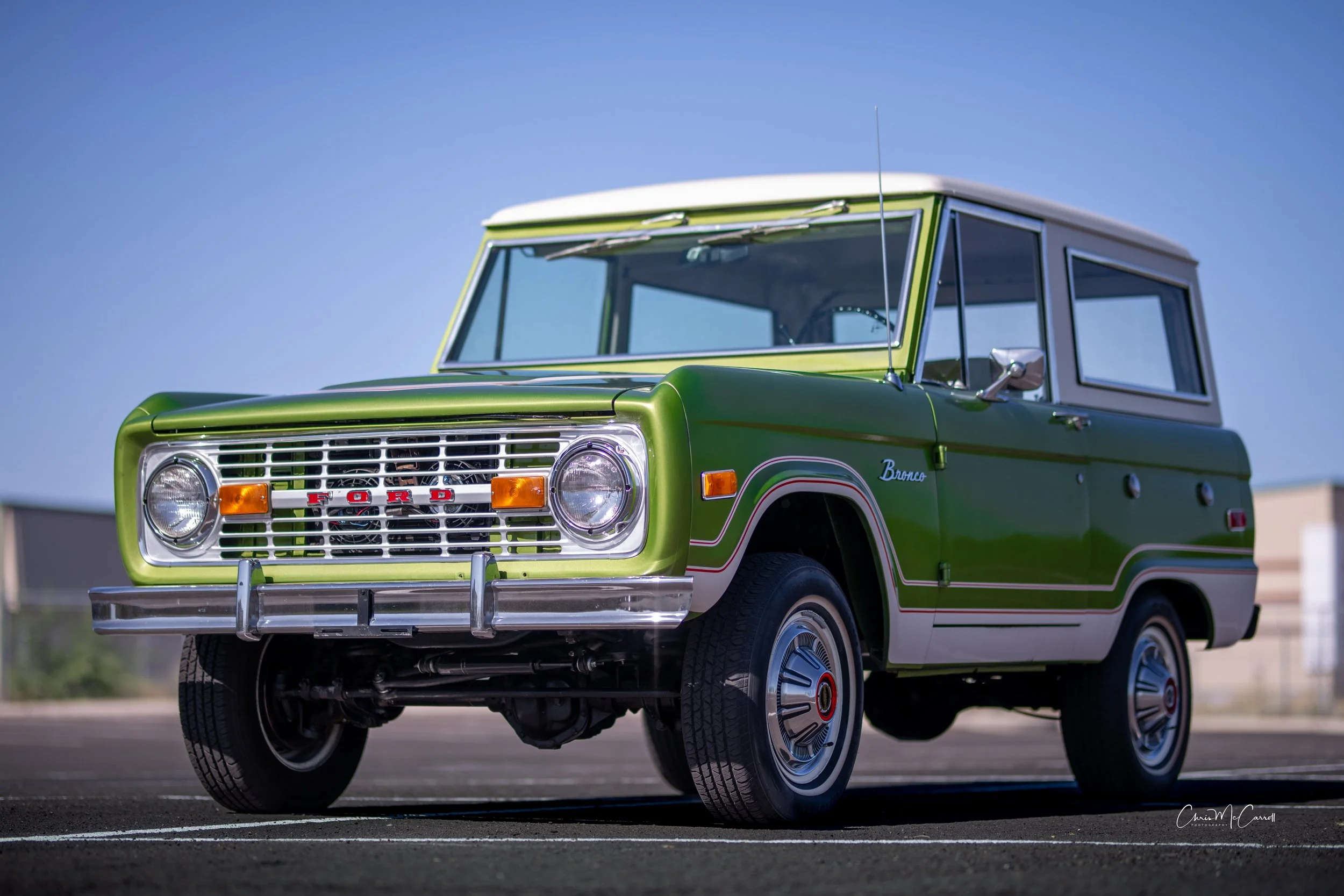 Classic green Ford Bronco photographed from a low three-quarter angle