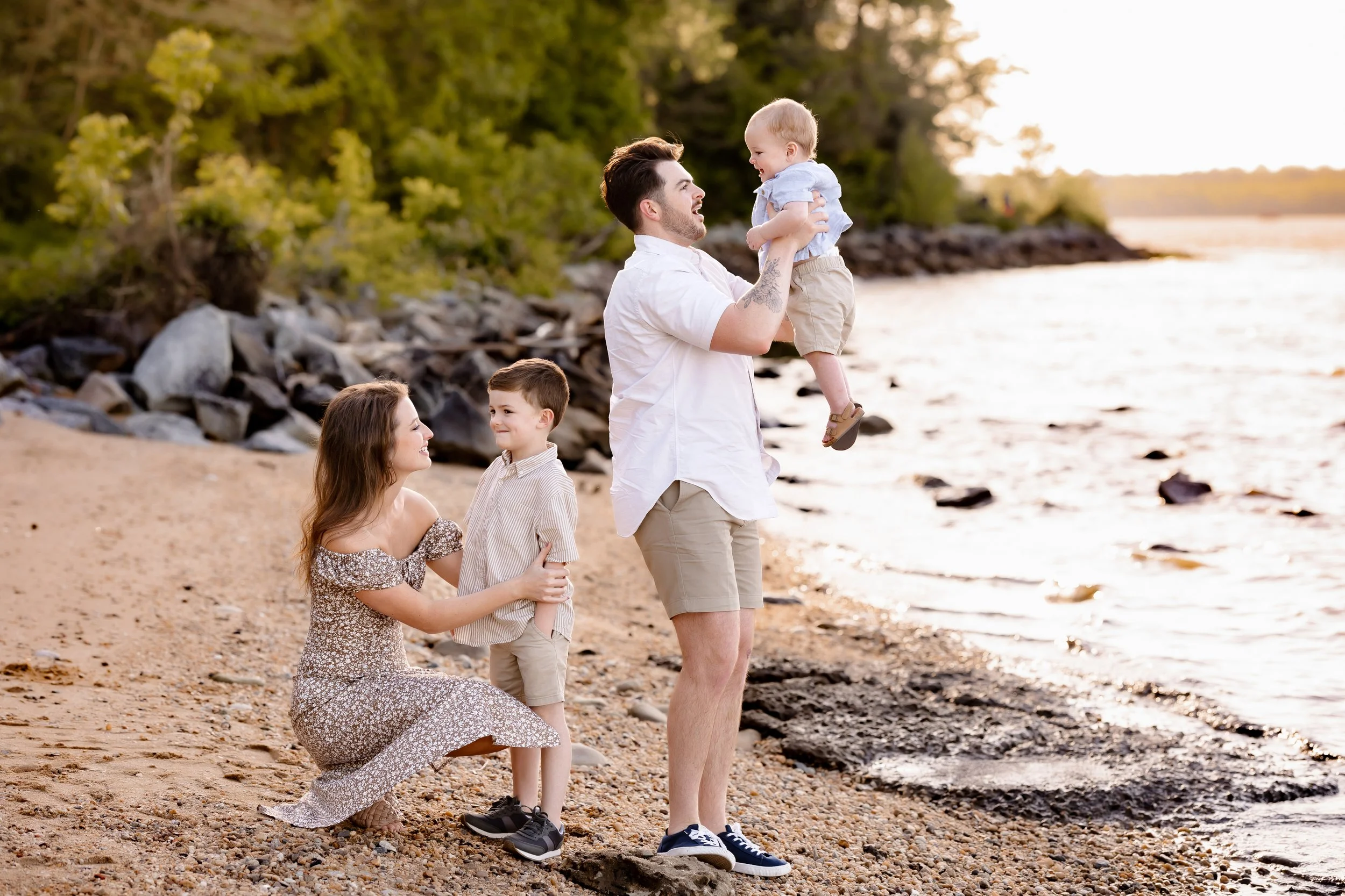 family of four along a riverfront during golden hour laughing and smiling together