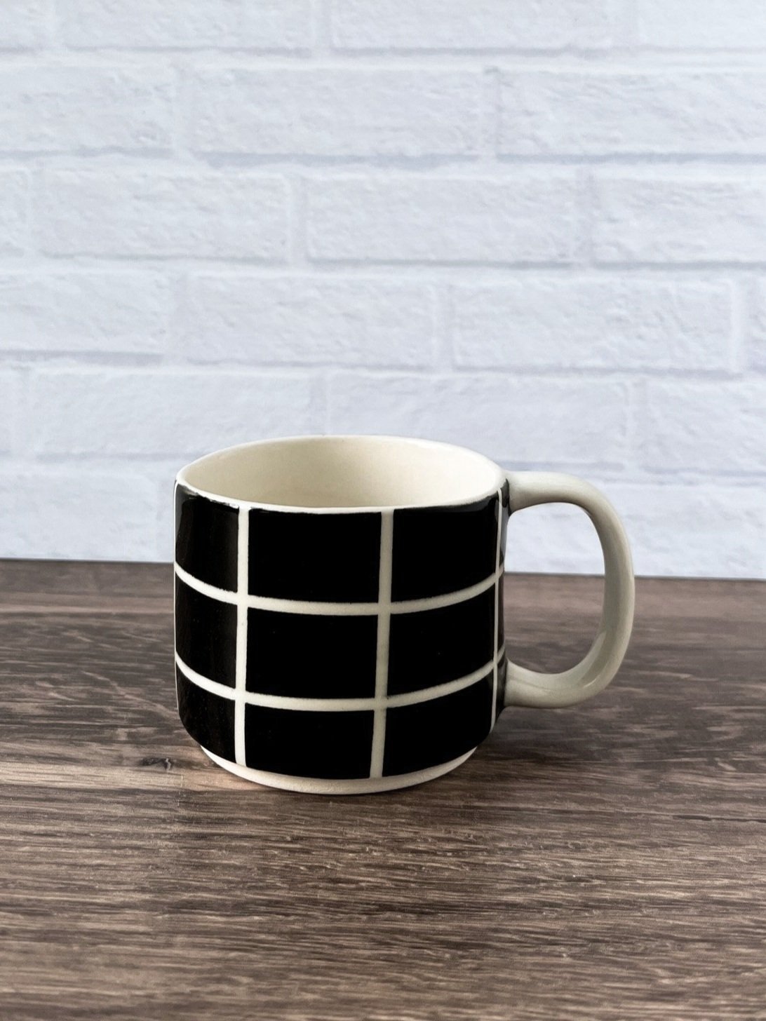Small black and white ceramic mug with bold grid pattern – handmade glossy stoneware cup