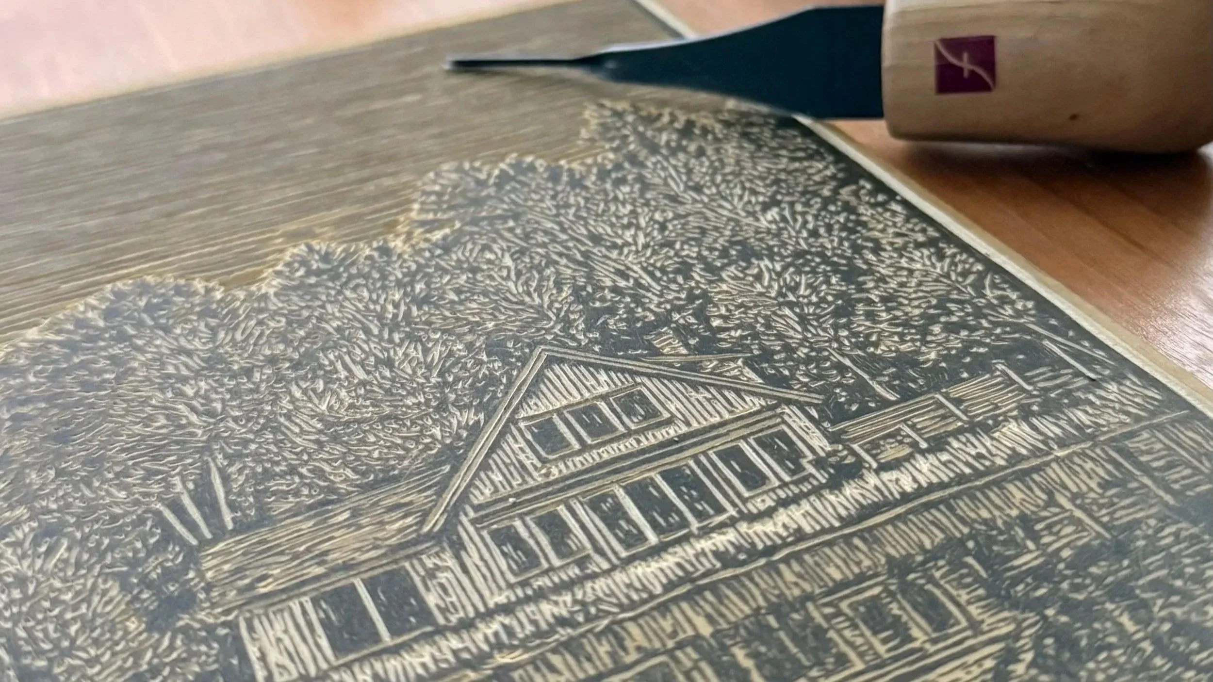 Close-up of a hand-carved linocut block with detailed relief printmaking linework