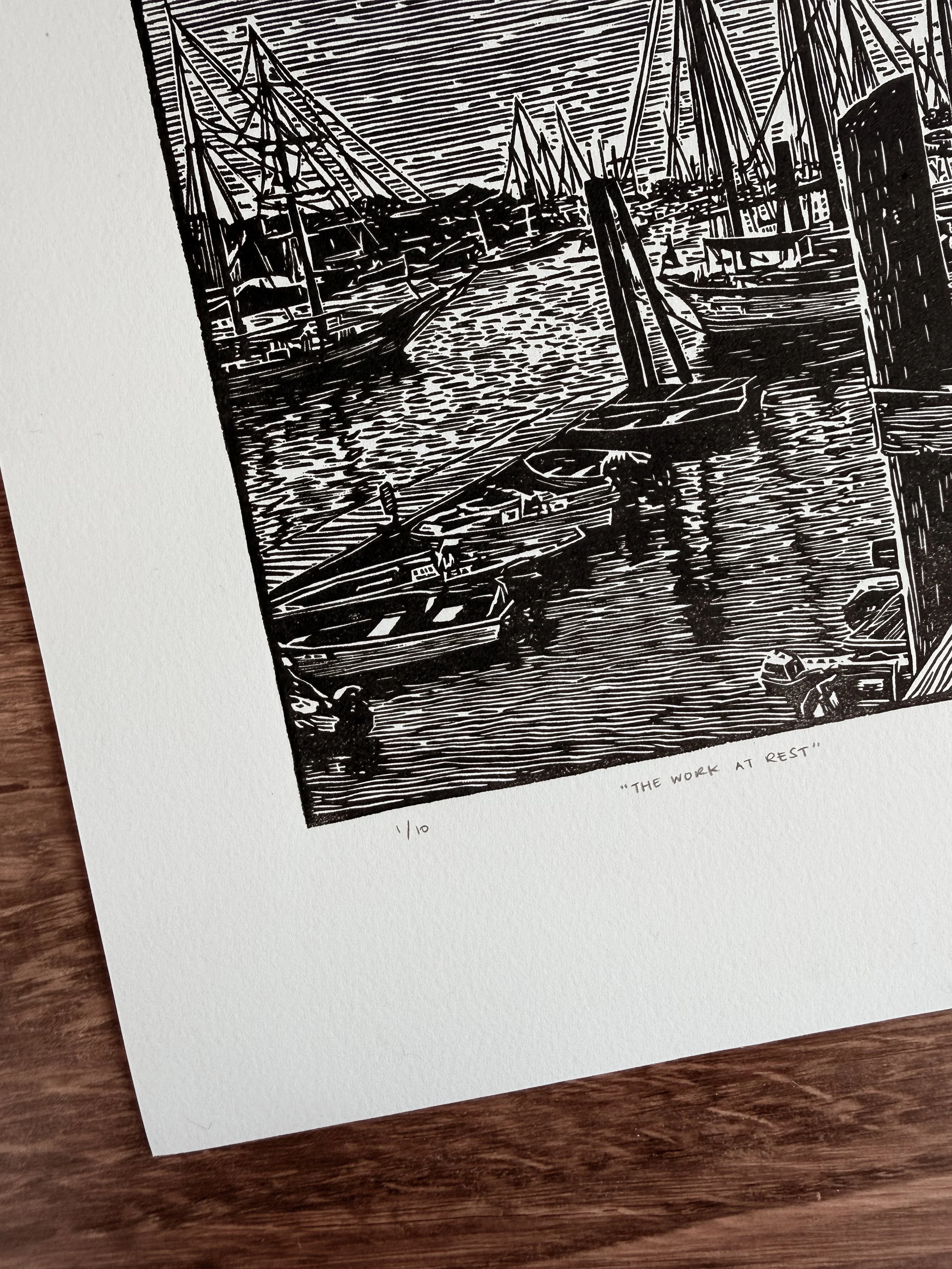 Close-up of linocut print showing boats at dock and water texture with carved line detail