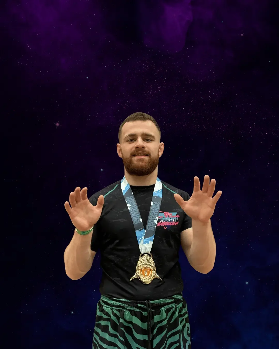 A man with a beard wears a medal around his neck, a black T-shirt, and zebra-striped shorts, standing against a space-themed background with stars and nebulae.