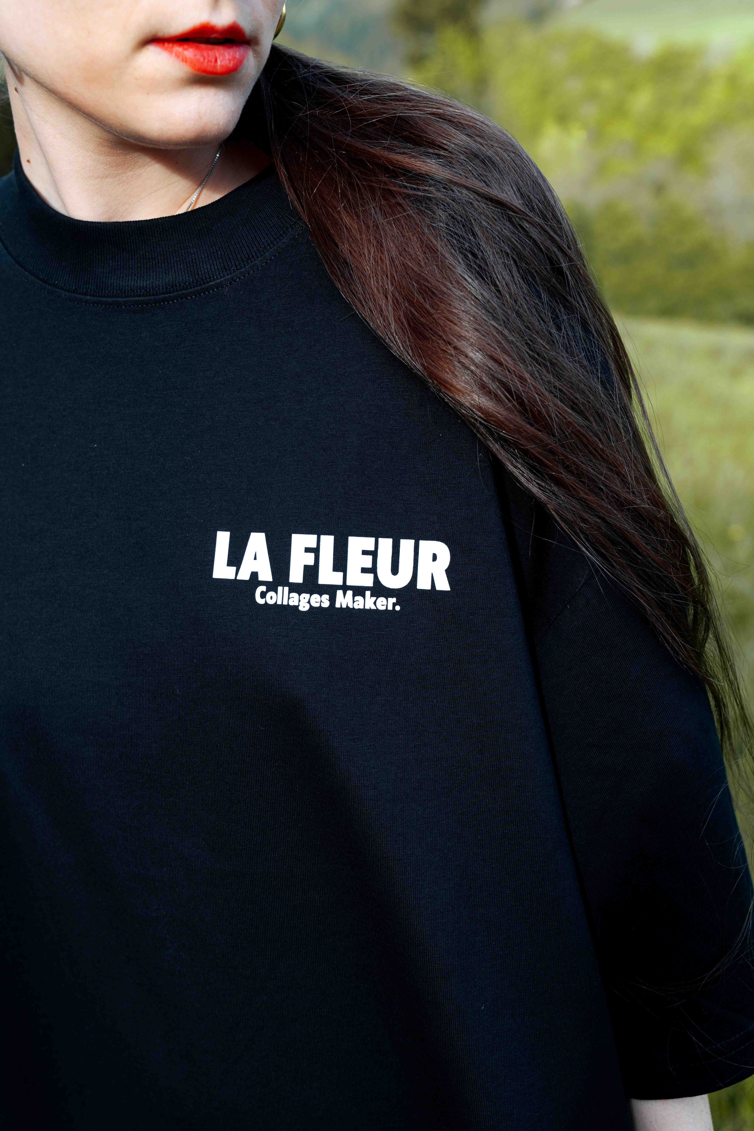 T-shirt oversize noir avec logo imprimé sur la poitrine, porté de face.