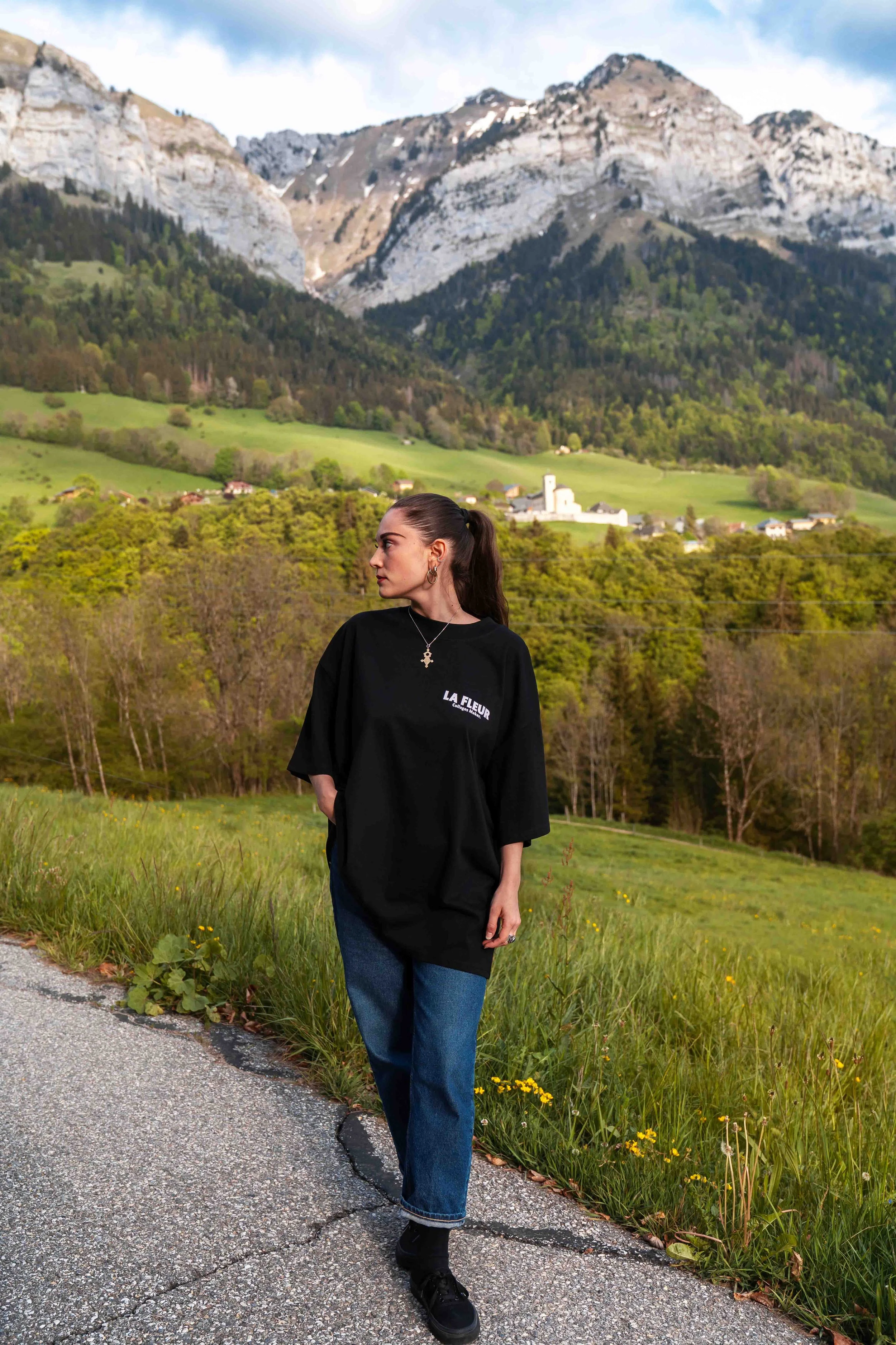 T-shirt oversize noir avec logo imprimé sur la poitrine, porté de face.