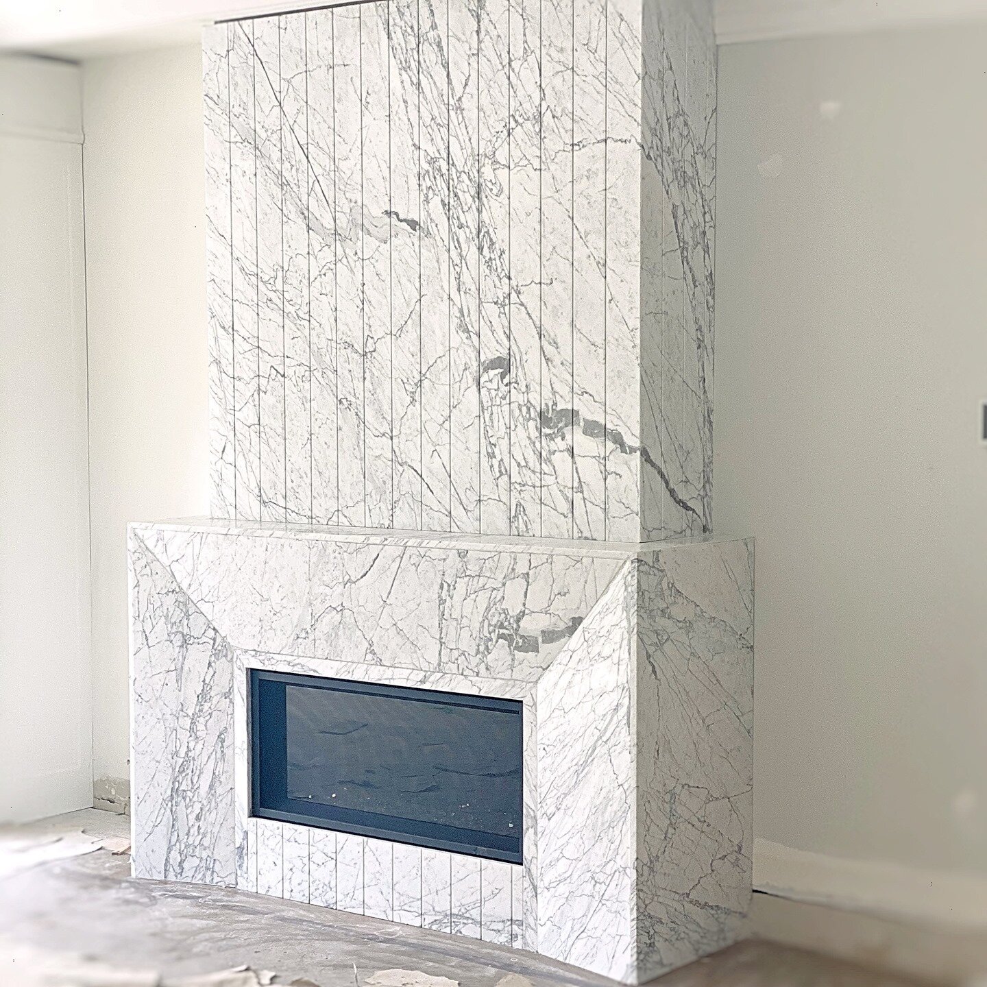 Calacutta Belgia from @Ciot.toronto compliments the beautiful fluted effect on the Fireplace surround designed by the talented @bananarch and installed by @elegancemarble 
#elegancemarble #calacuttabelgia #interiordesign #fireplacesurround #newhomes 