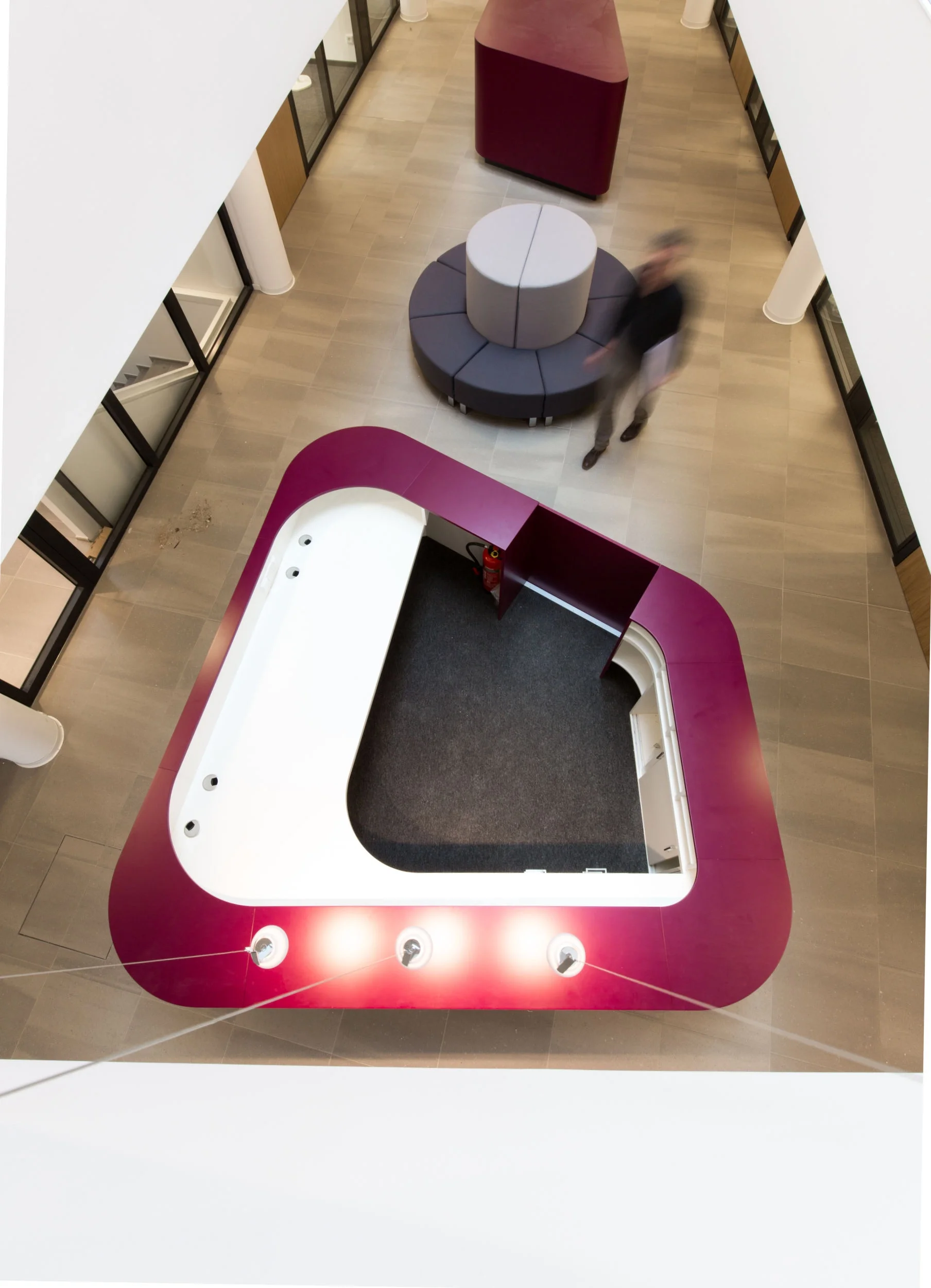 Blick aus dem 1. Obergeschoß auf die organisch geformten Empfangsmöbel.