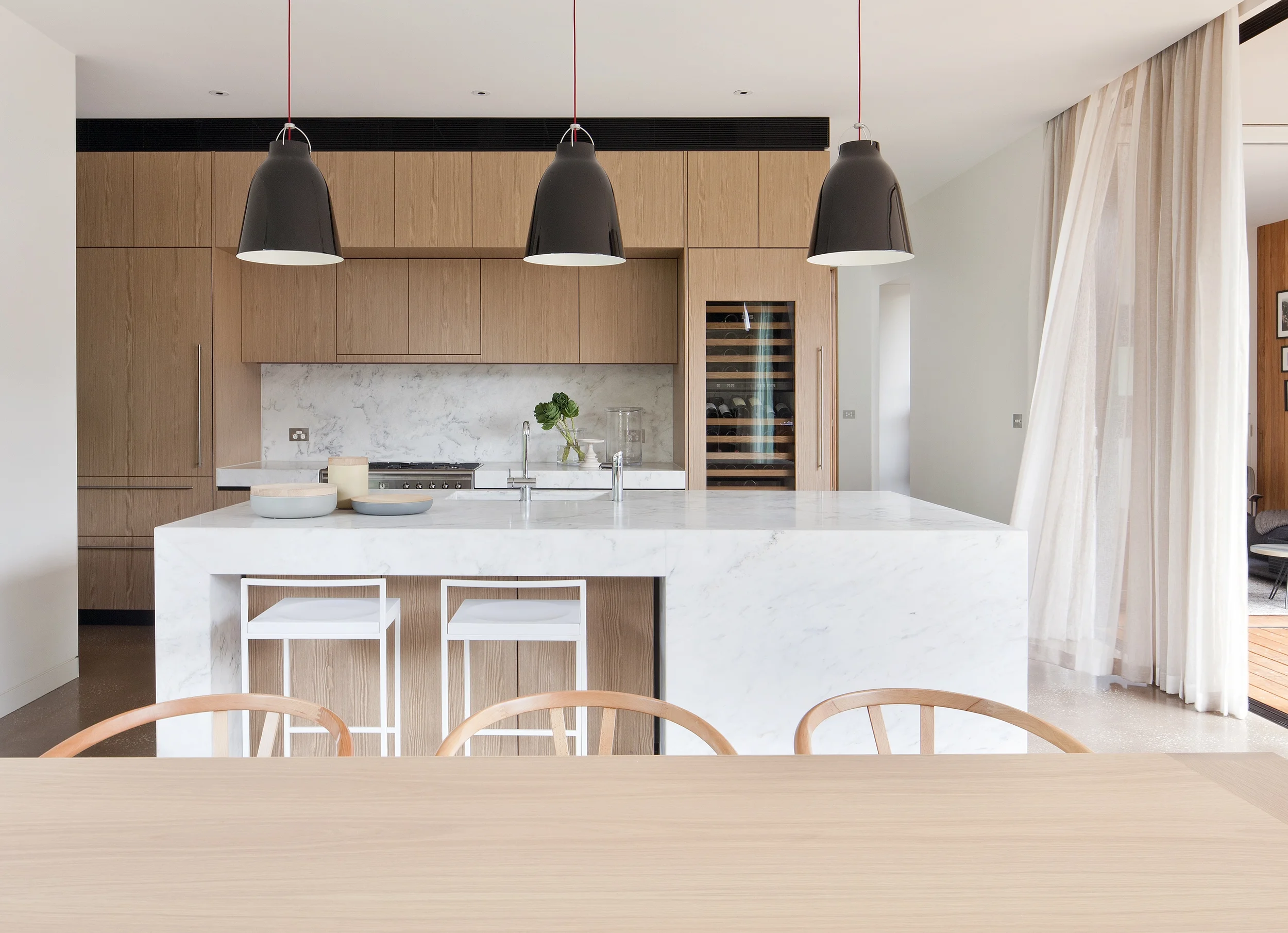 Modernes Küchendesign mit einer Kücheninsel aus Marmor und Küchenmöbeln in Holzfurnier