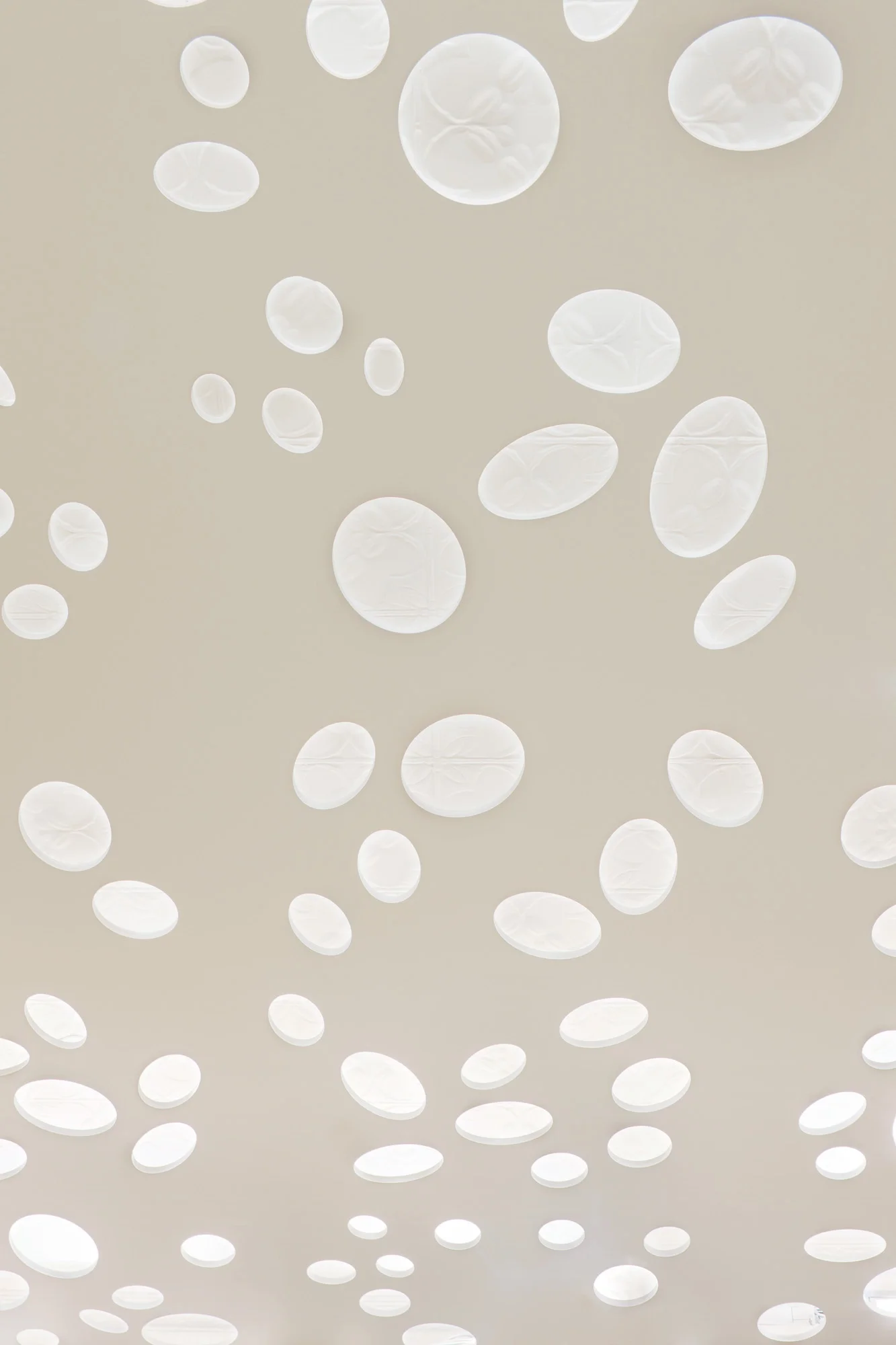 Detailansicht der perforierten Abhangdecke. Zu sehen ist die alte, verzierte Metalldecke des Ladengeschäfts, die erhalten wurde.